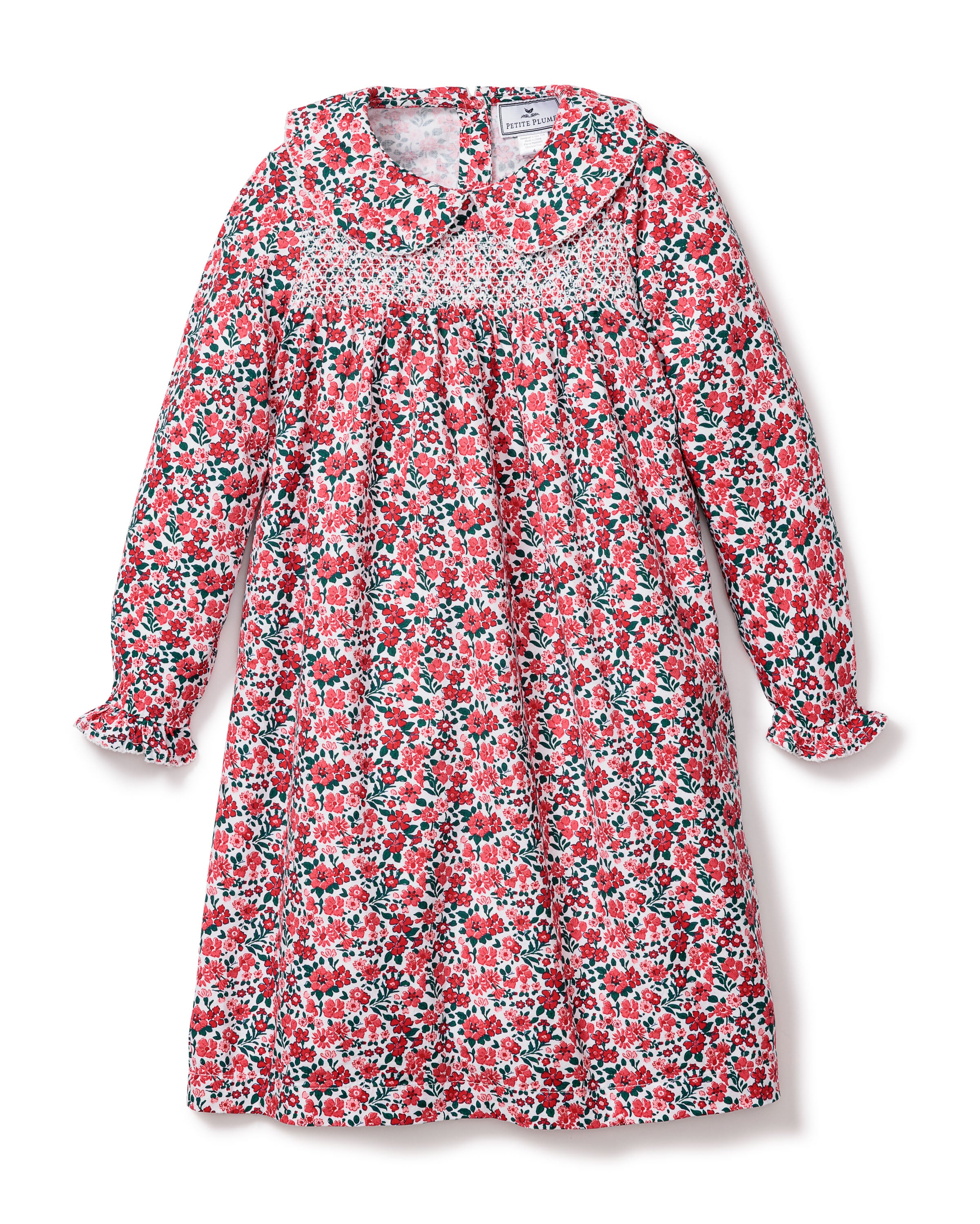 The Girls Eloise Nightgown in Fleurs des Bois by Petite Plume is a long-sleeved garment with a floral print, peter pan collar, elastic chest gathering, and ruffled cuffs. Its made from moisture-wicking twill weave in red, green, and white for a vintage-inspired look.