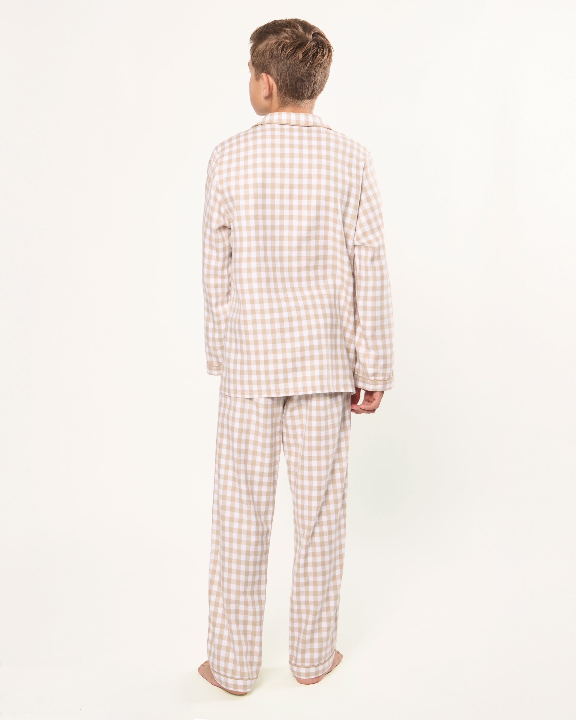 Kid's Twill Pajama Set in Camel Gingham features long sleeves, pants with an elastic waistband, and a button-up shirt with a collar and front pocket, all in a beige and white gingham check pattern.