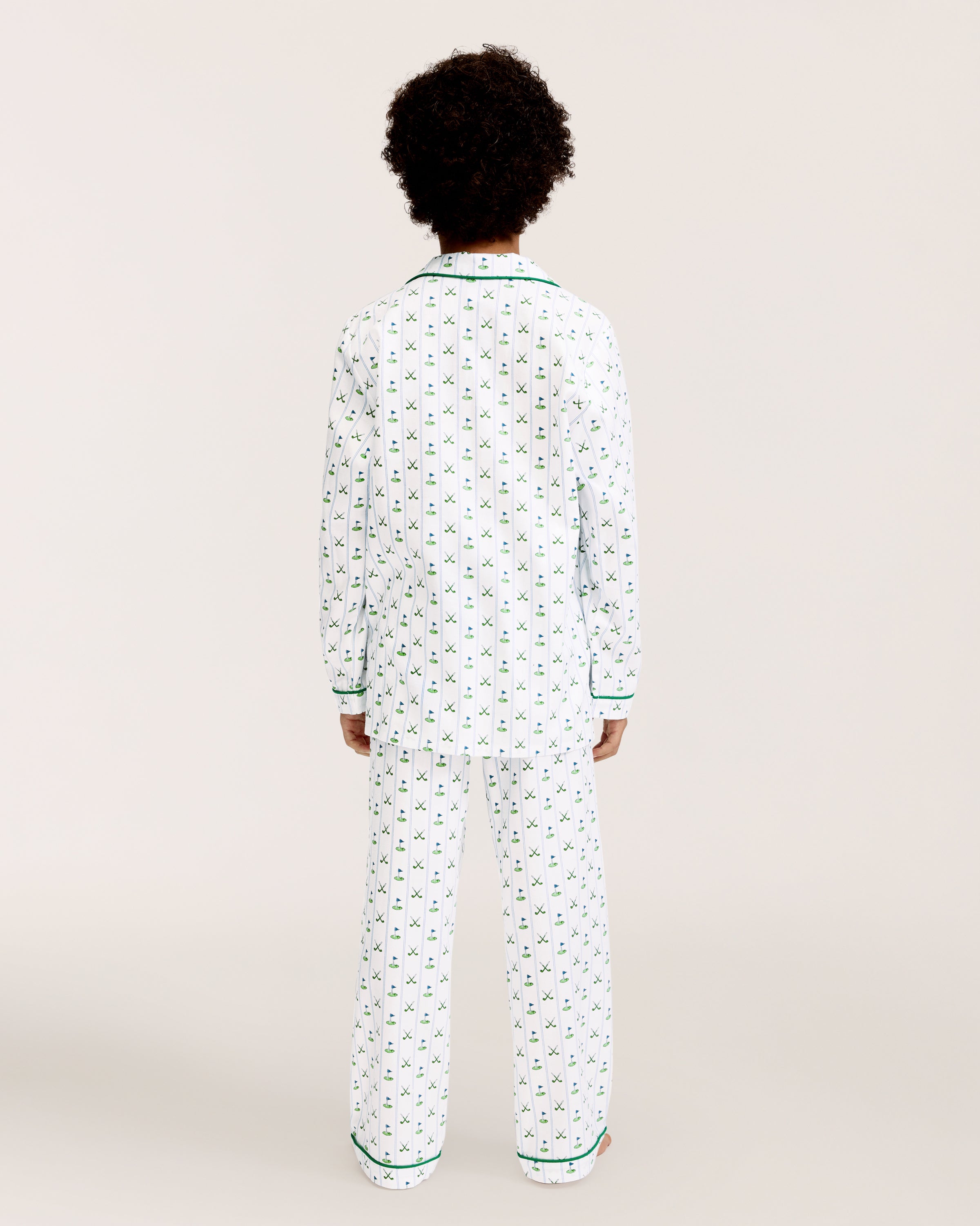 The Kid's Twill Pajama Set in Fairway Stripe features white pajamas with green piping, a tennis racket and green stripe pattern, a long-sleeve button-up top with a chest pocket, and matching long pants.