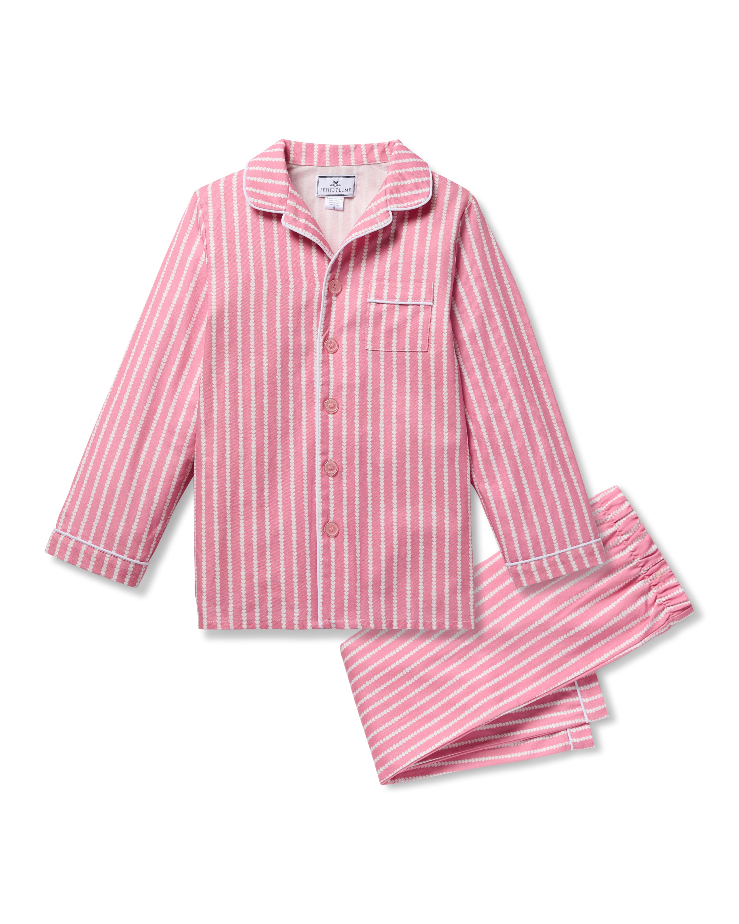 The Kids Twill Pajama in Love Lines by Petite Plume is a charming two-piece set with pink and white yarn-dyed stripes. Featuring a long-sleeve top with collar, front pocket, buttons, and elastic waist pants, its designed for comfort and style against a plain white backdrop.