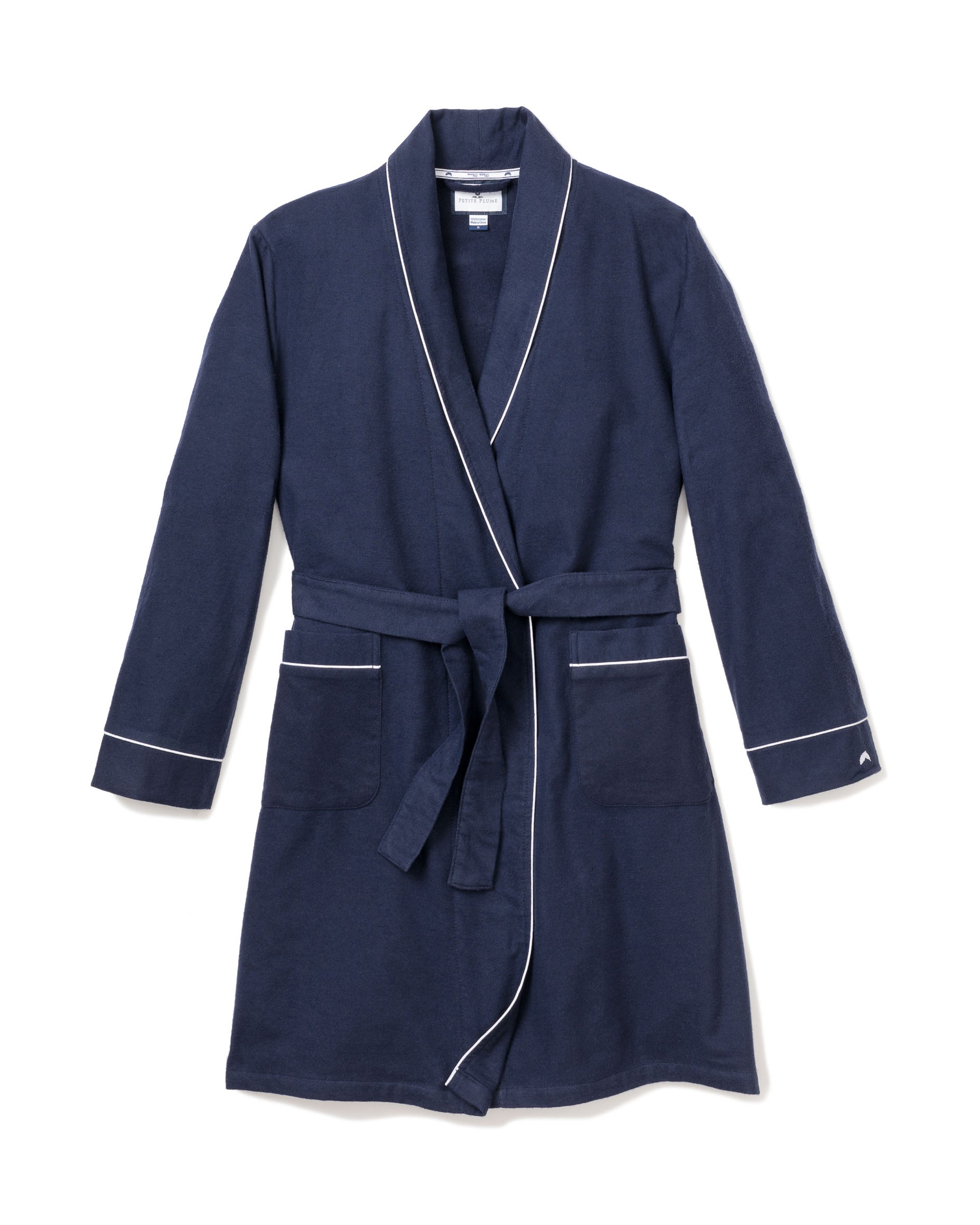 The Kids Flannel Robe in Navy with White Piping by Petite Plume is perfect for childrens sleepwear. It features a belt at the waist, two front pockets, long sleeves, and is made from flame-retardant material for added safety.