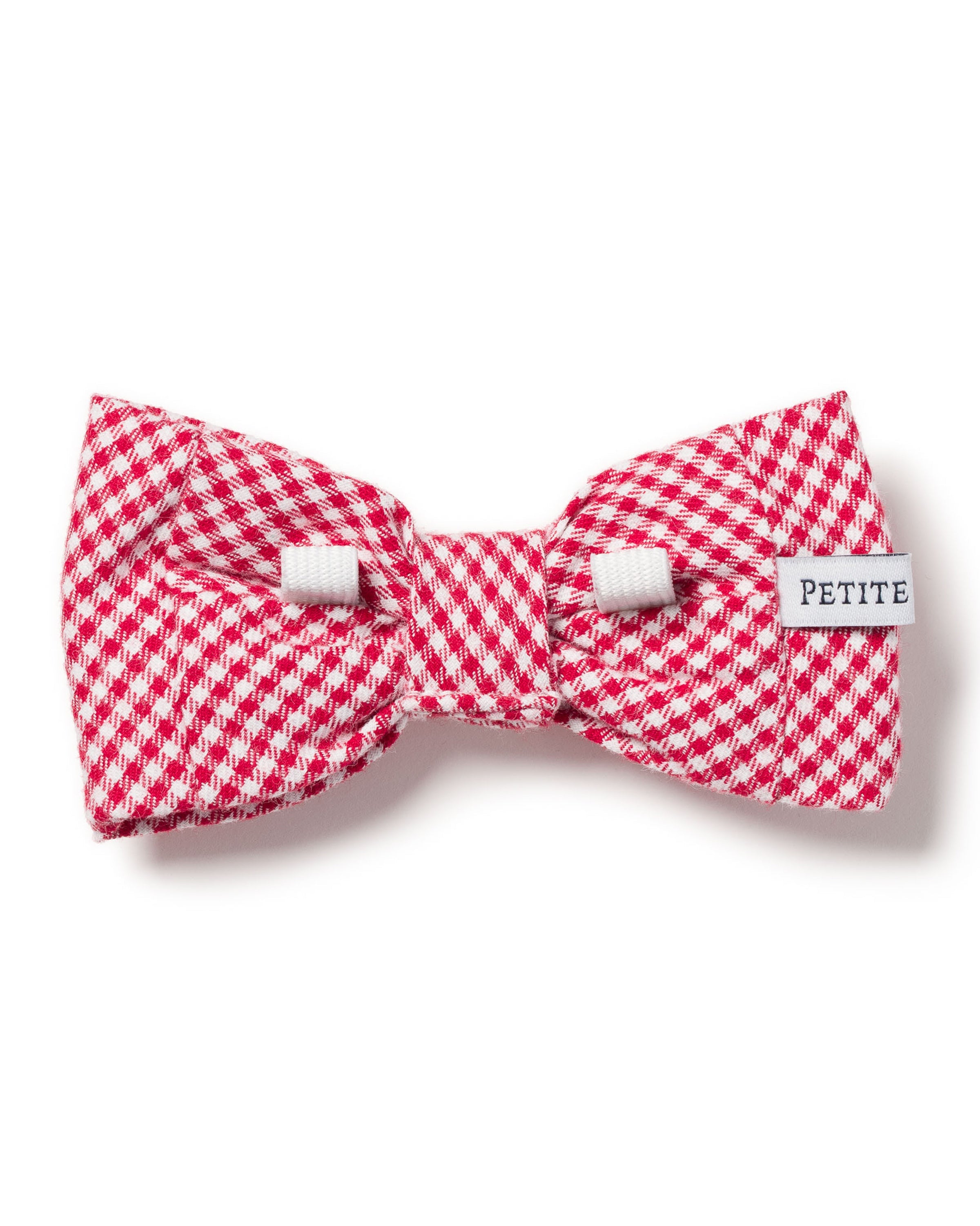 The Red Mini Gingham Dog Bow Tie by Petite Plume features a red and white houndstooth pattern and a PETITE tag on the side, set against a plain white background—ideal for anyone looking for festive dog accessories.