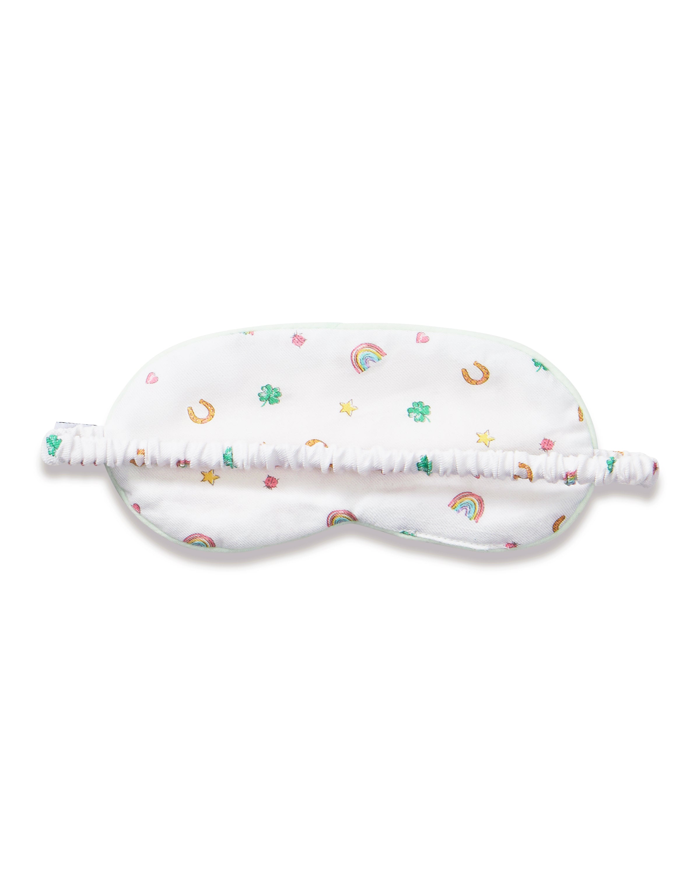 A young girl with long brown hair wears the Kid's Twill Sleep Mask in Good Luck Charms and a matching pajama top featuring rainbows, horseshoes, and clovers, standing against a neutral background.