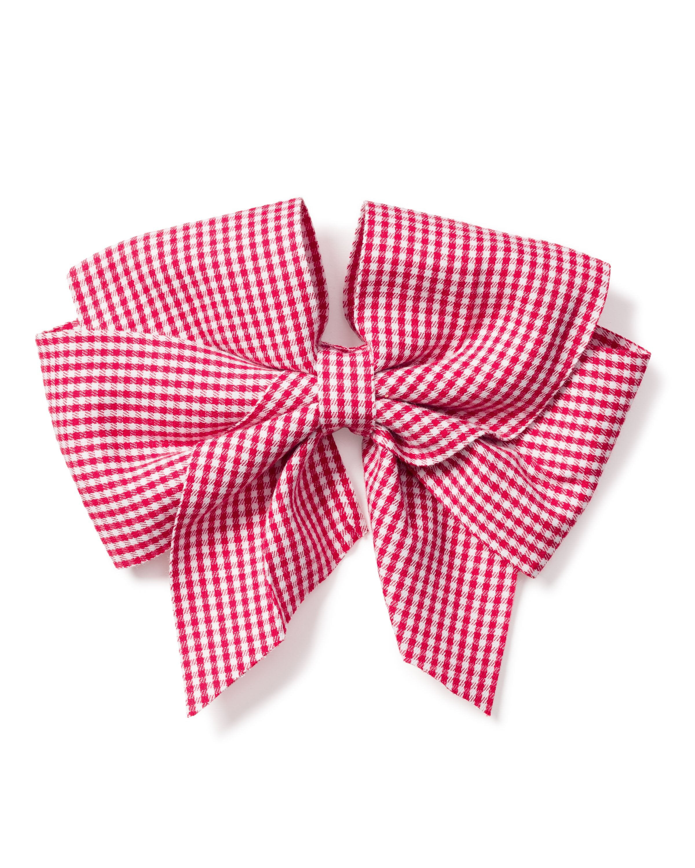 The Petite Plume Girls Hair Bow in Red Mini Gingham, crafted from charming fabrics with multiple loops and tails, serves as a delightful accessory displayed against a plain white background.