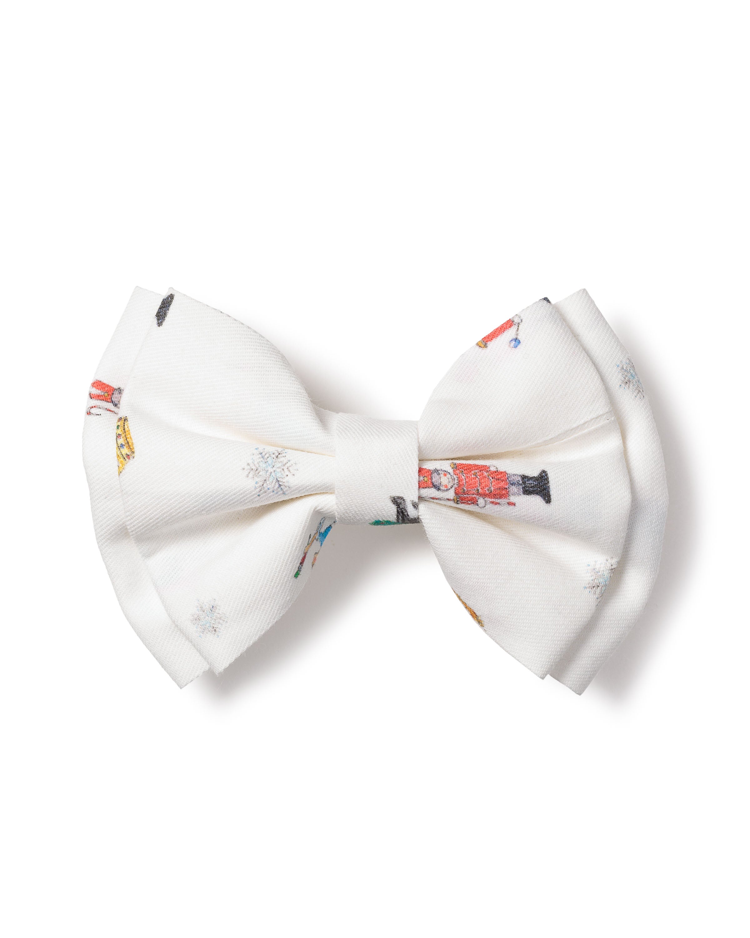 The Girls Twill Hair Bows in A Night at the Nutcracker by Petite Plume feature nutcracker images and subtle snowflakes, adding a playful touch reminiscent of a Sugar Plum Fairys whimsical charm.
