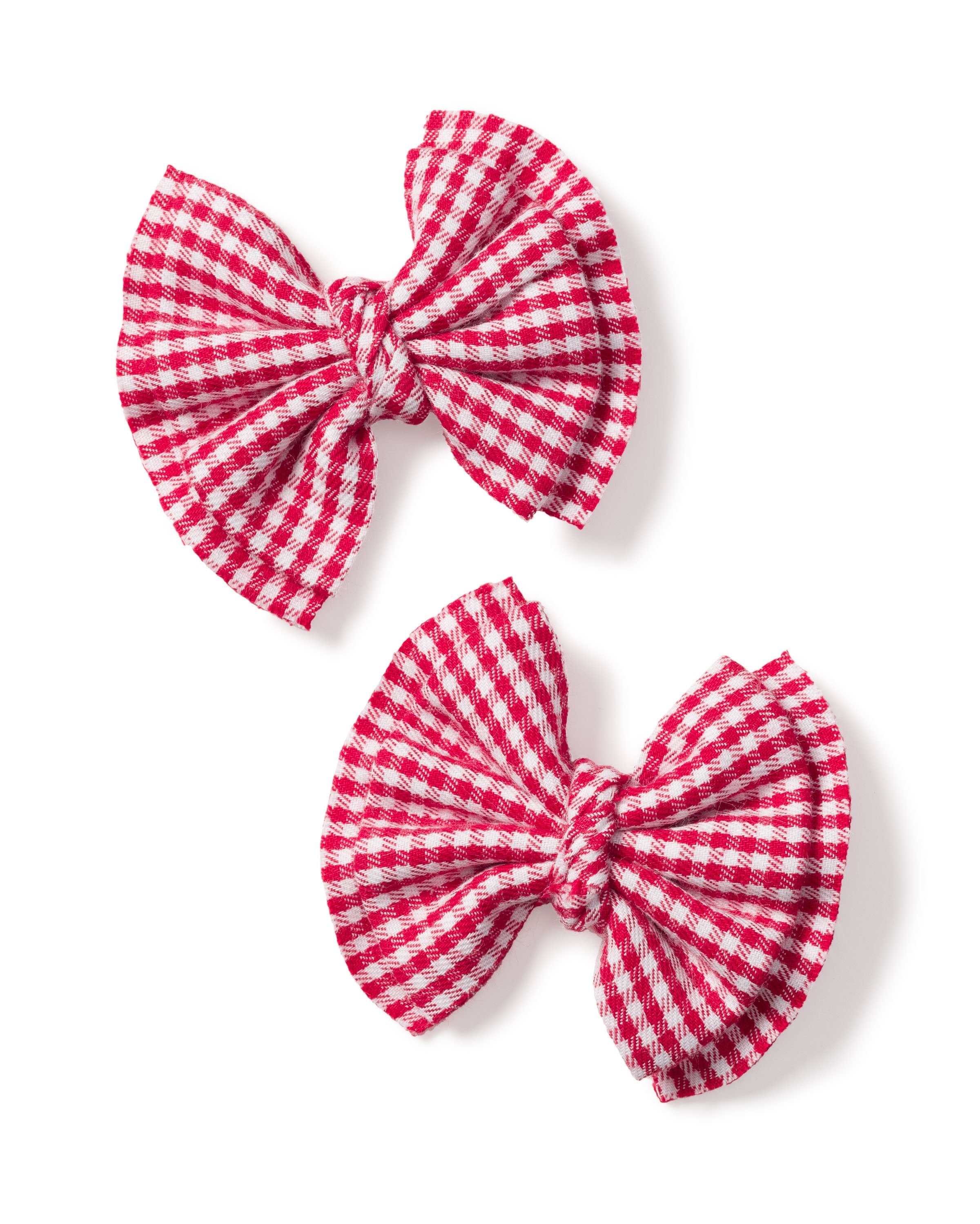 The Petite Plume Girls Hair Bows in Red Mini Gingham feature two knotted bows on a white background with a classic red and white checkered pattern, perfect for adding a playful touch to pajama party outfits.