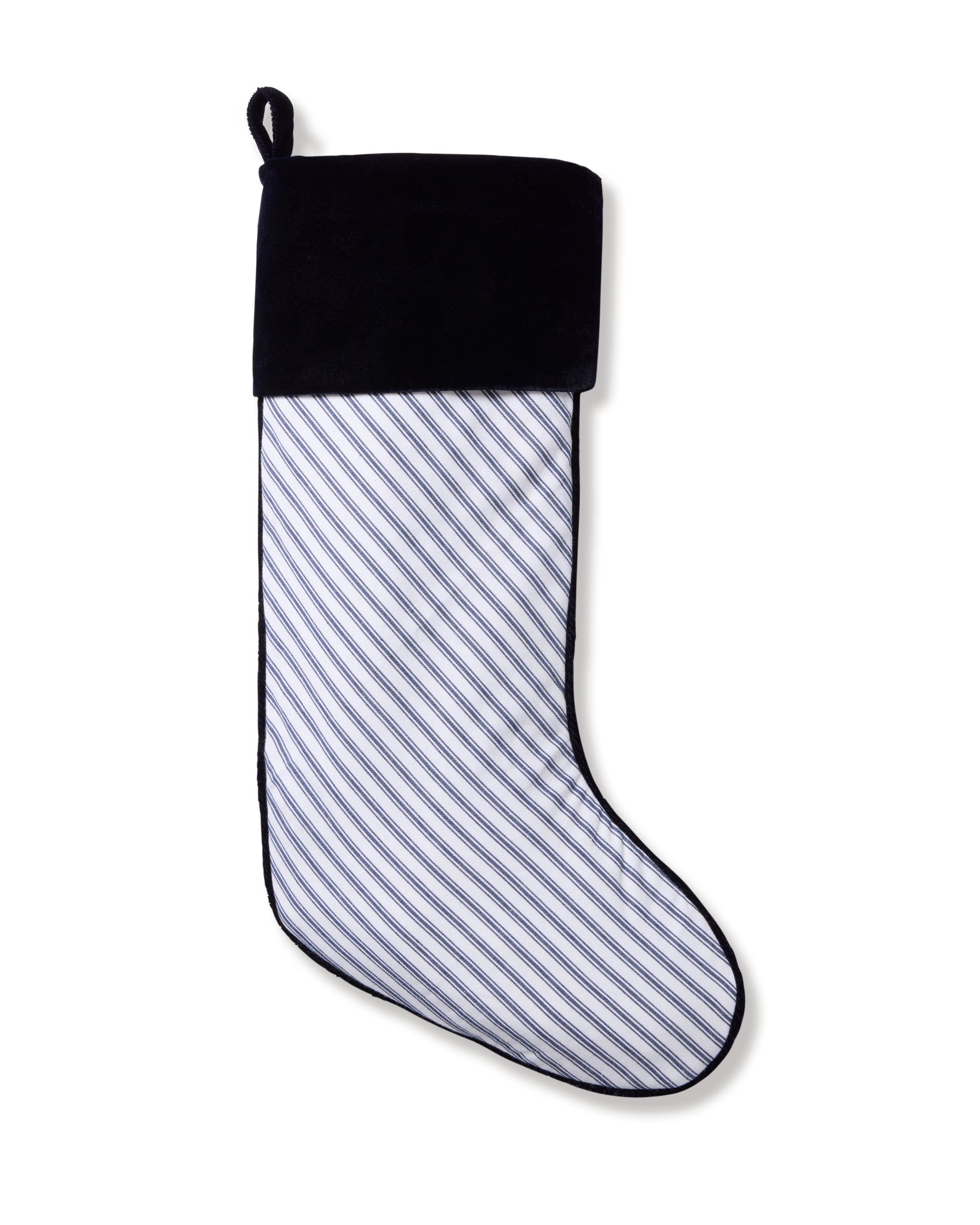The Petite Plume Christmas Stocking in Navy French Ticking features a monogrammable design with a white body and diagonal blue stripes, plus a plush velour cuff and hanging loop, making it an elegant addition to your holiday decor.