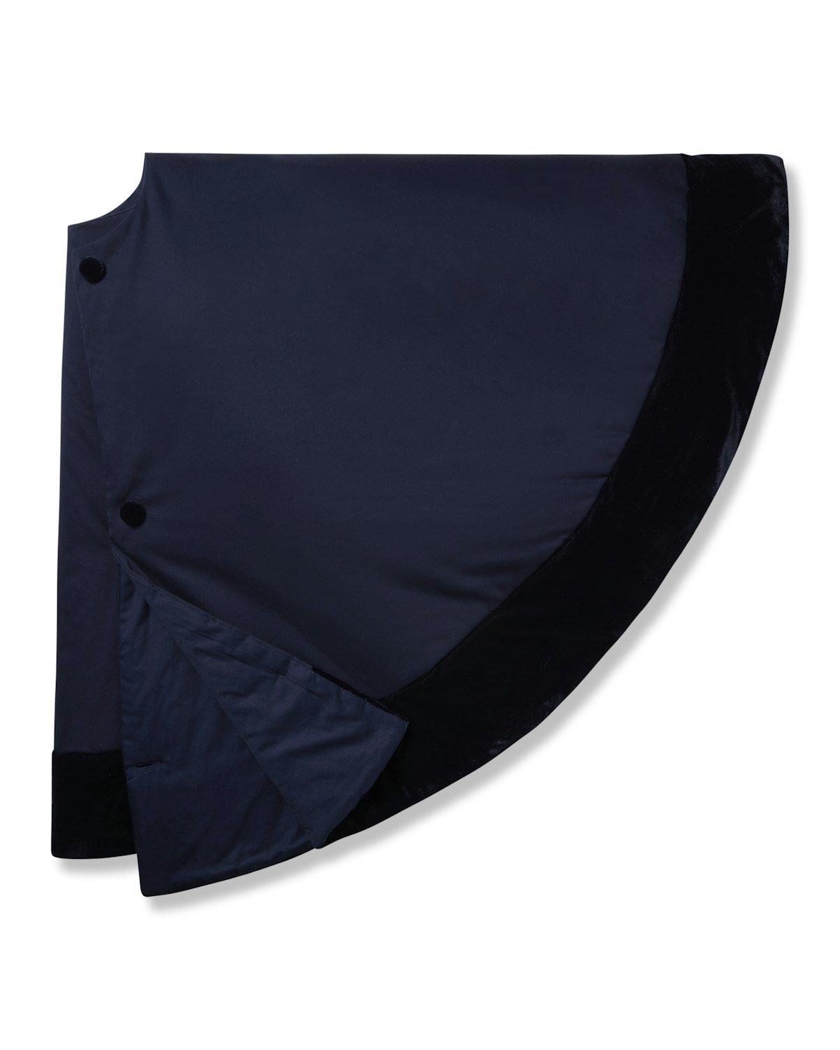 The Christmas Tree Skirt in Navy by Petite Plume features a smooth, slightly shiny fabric with black accents and a button closure. Its flared silhouette, reminiscent of elegant holiday decor, makes it perfect for monogramming against a white background.