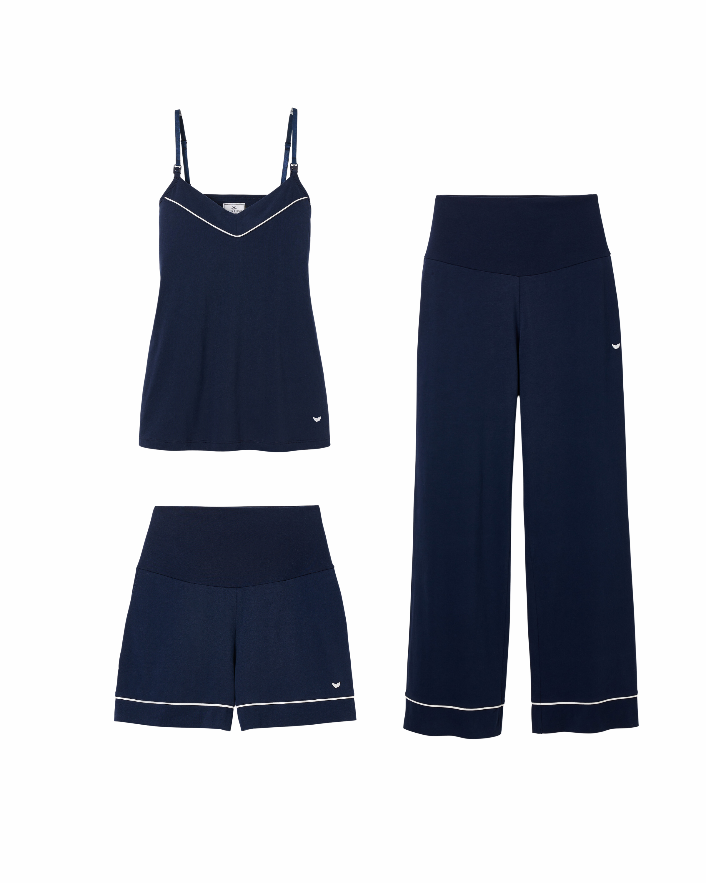 The Basics Maternity Set in Navy by Petite Plume includes a camisole with spaghetti straps and white trim, high-waisted wide-leg pants, and matching shorts. Made from luxurious Pima cotton, each piece has an embroidered logo, ensuring comfort ideal for maternity wear.