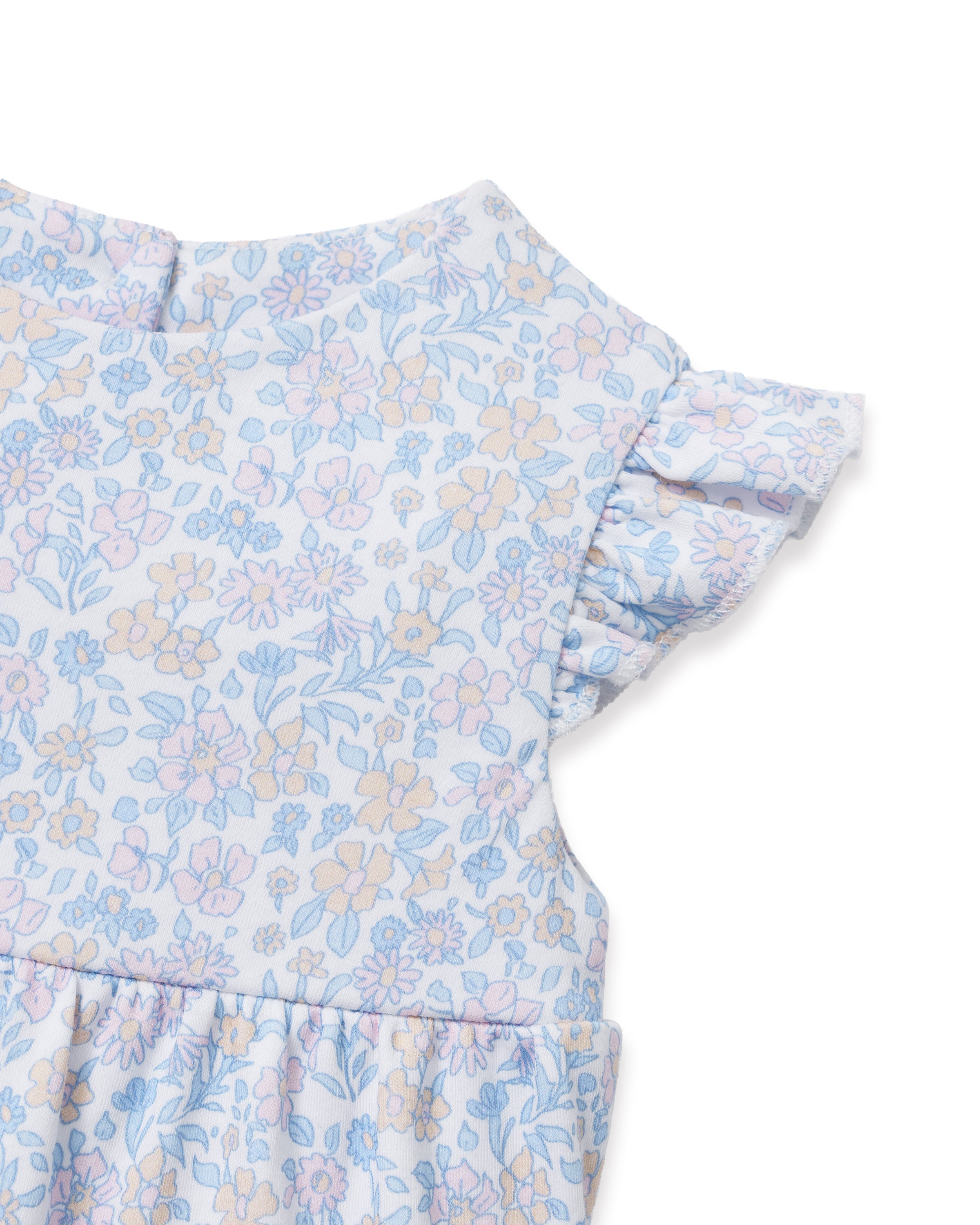 The Baby's Pima Isla Play Romper in Fleur Blanche features light blue and white florals, short ruffled sleeves, and elastic leg openings, shown laid flat on a white background.