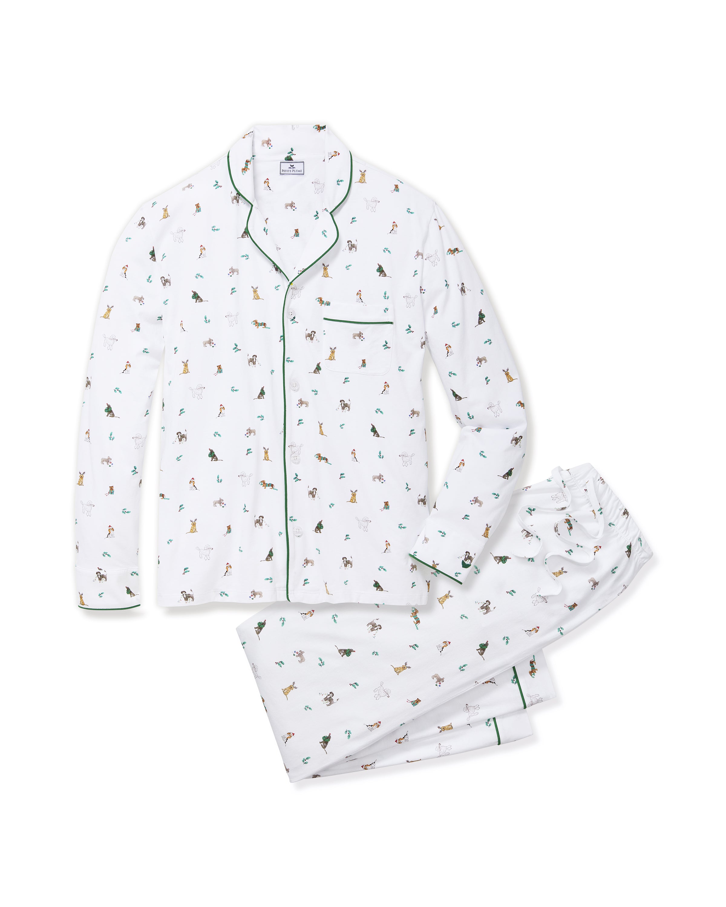 A person smiles in Petite Plumes Mens Pima Pajama Set in Jingle Paws, featuring colorful animal designs on soft Peruvian Pima cotton with green piping and a chest pocket against a plain, light background, enhancing their cheerful appearance.