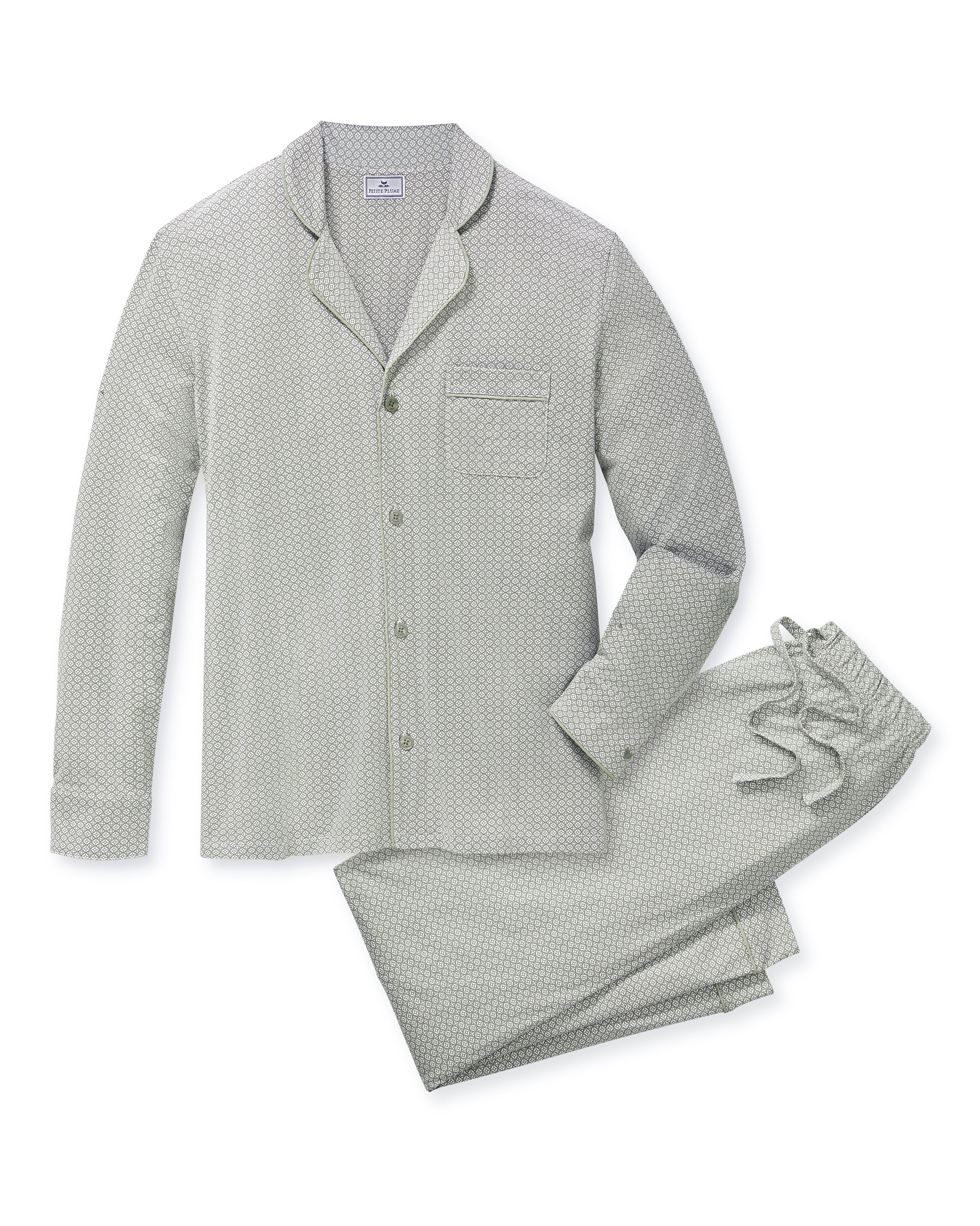 A man with short gray hair and light stubble stands barefoot in the Men's Lightweight Pima Pajama Set in Sage Geo against a white background, gazing to the side with a relaxed expression.