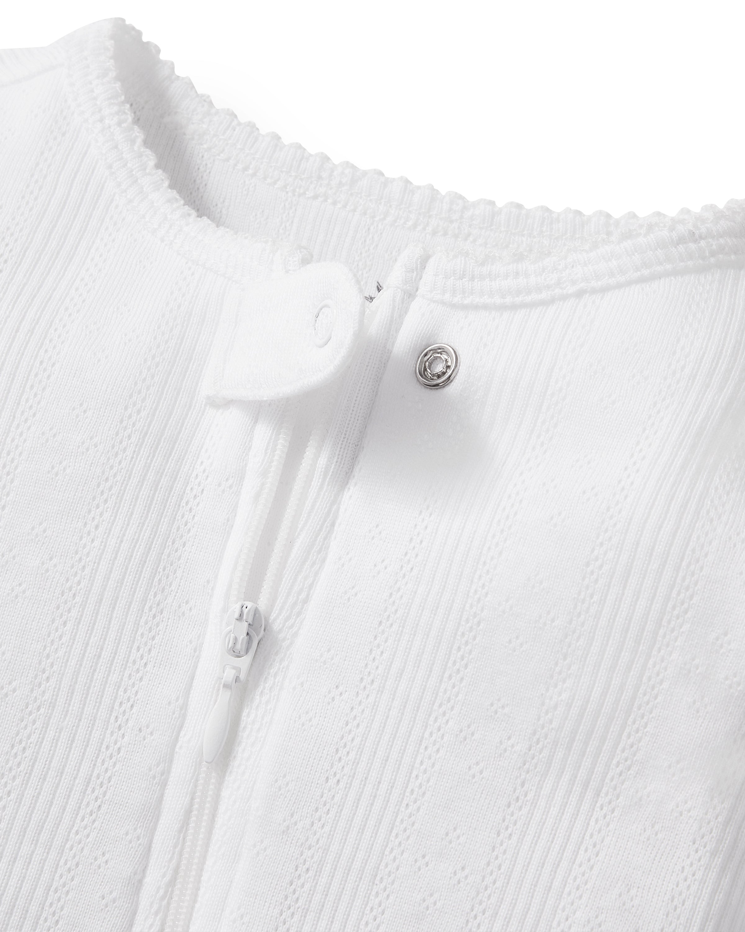 The Baby's Pointelle Footie Romper in White features long sleeves, covered feet, a front zipper, and a single neckline button, shown laid flat on a white background.