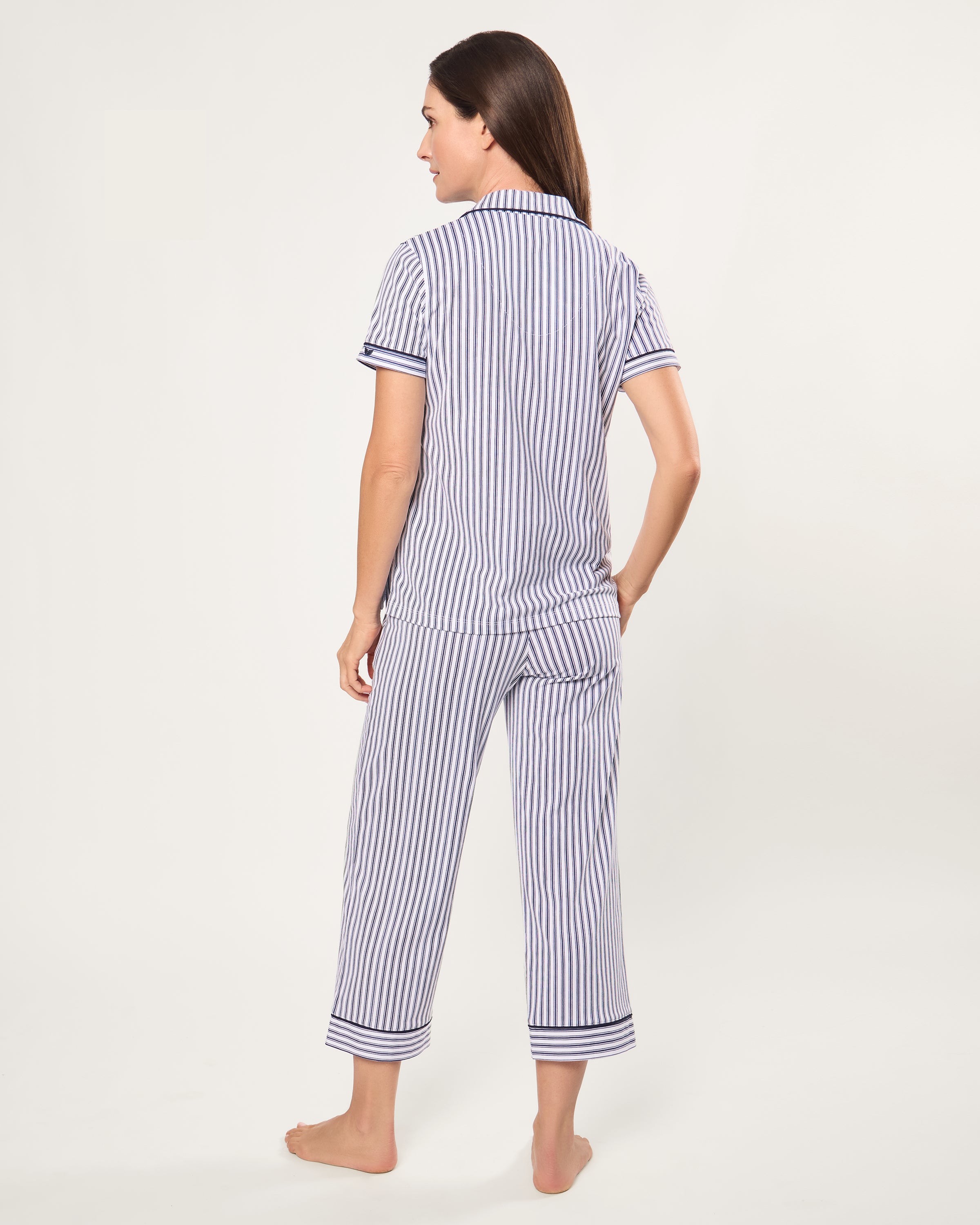 The Women's Pima Crop Pajama Set in Navy French Ticking features a blue and white vertical stripe design, short sleeves, a collared button-up top with chest pocket, and matching long pants.