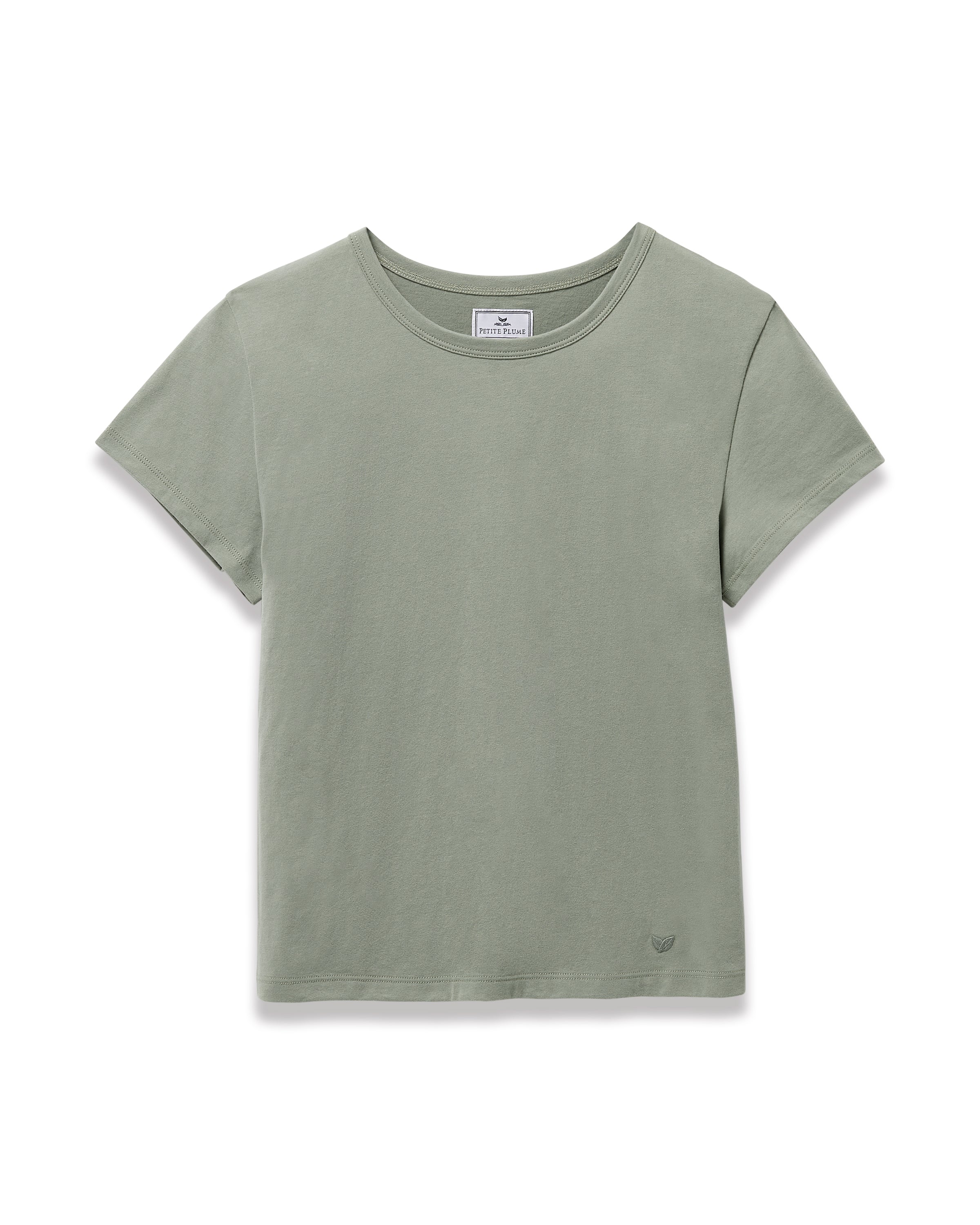 A woman with straight brown hair wears the Women's Pima Essential Crew Neck Tee in Sage and matching drawstring shorts, standing with her hands on her hips against a plain light background.