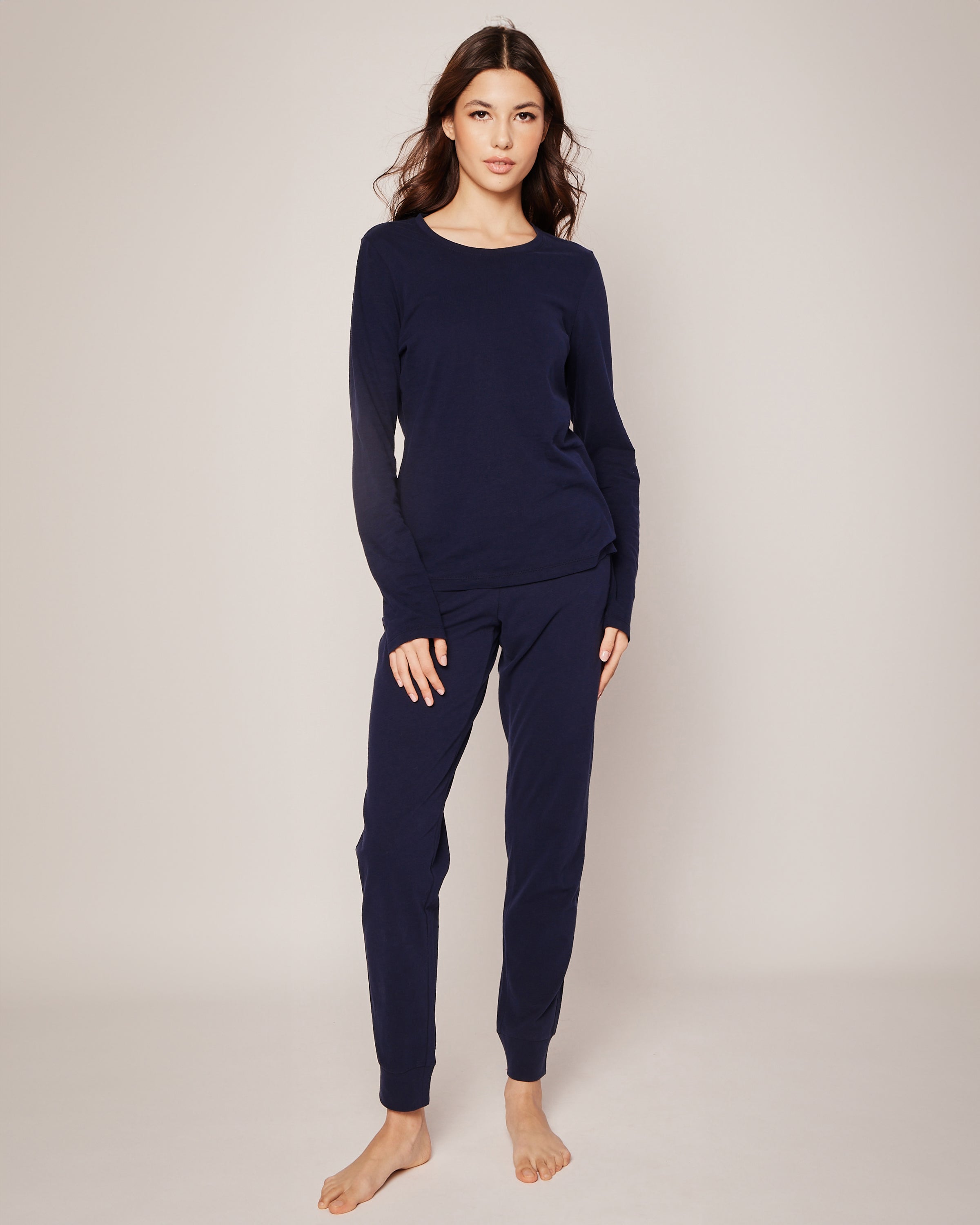Against a plain background, someone stands barefoot in luxurious Womens Pima Lounge Pants in Navy from Petite Plume, crafted from soft Peruvian Pima cotton.