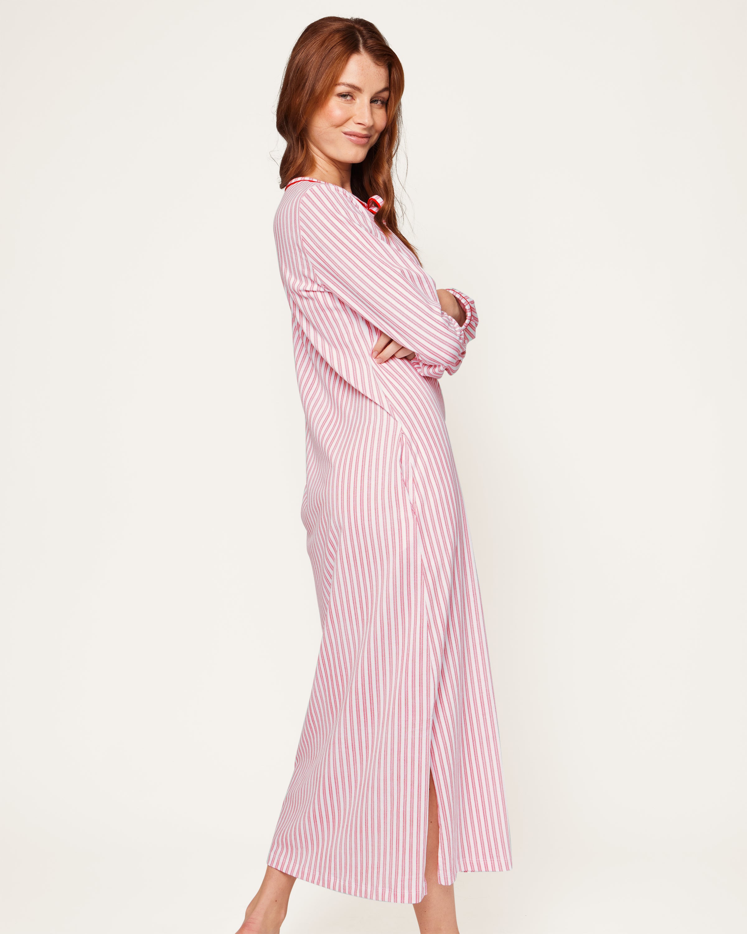 A close-up of the Womens Pima Harlow Nightgown in Antique Red Ticking showcases a red and white striped pattern, made from premium Peruvian Pima cotton. It features a keyhole neckline tied with matching fabric laces, with the Petite Plume label visible on top.
