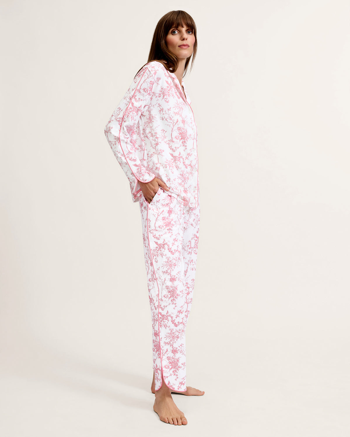 The Margaux Pima Pajama Set in Pink Timeless Toile features long sleeves, soft white fabric with a pink floral toile pattern, and pink piping along the edges and collar.