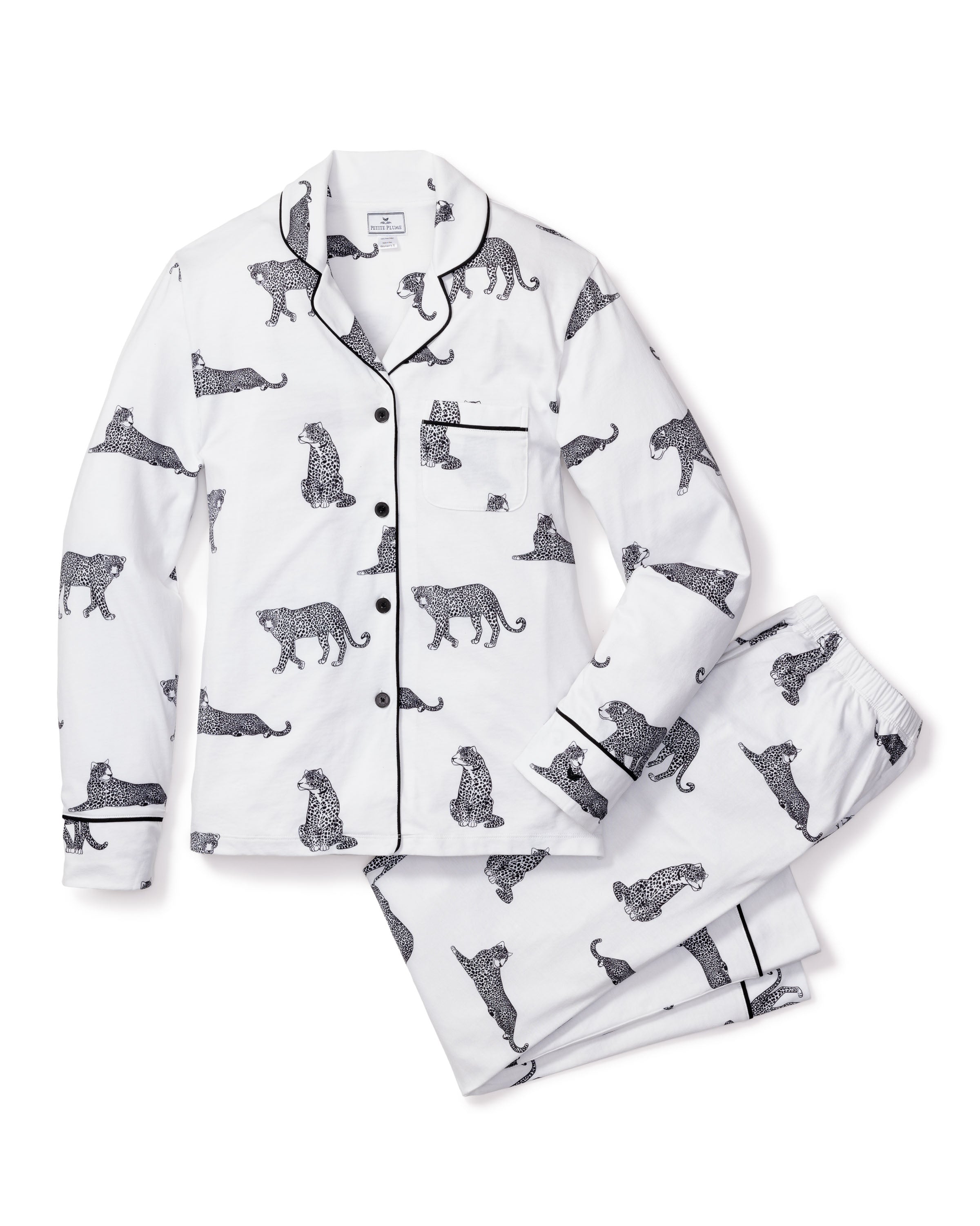 The Petite Plume Womens Pima Pajama Set in Panthère de Paris features a white, long-sleeve button-up top and pants made of Peruvian Pima cotton, adorned with elegant black leopard sketches and detailed with black piping on the collar and pockets.