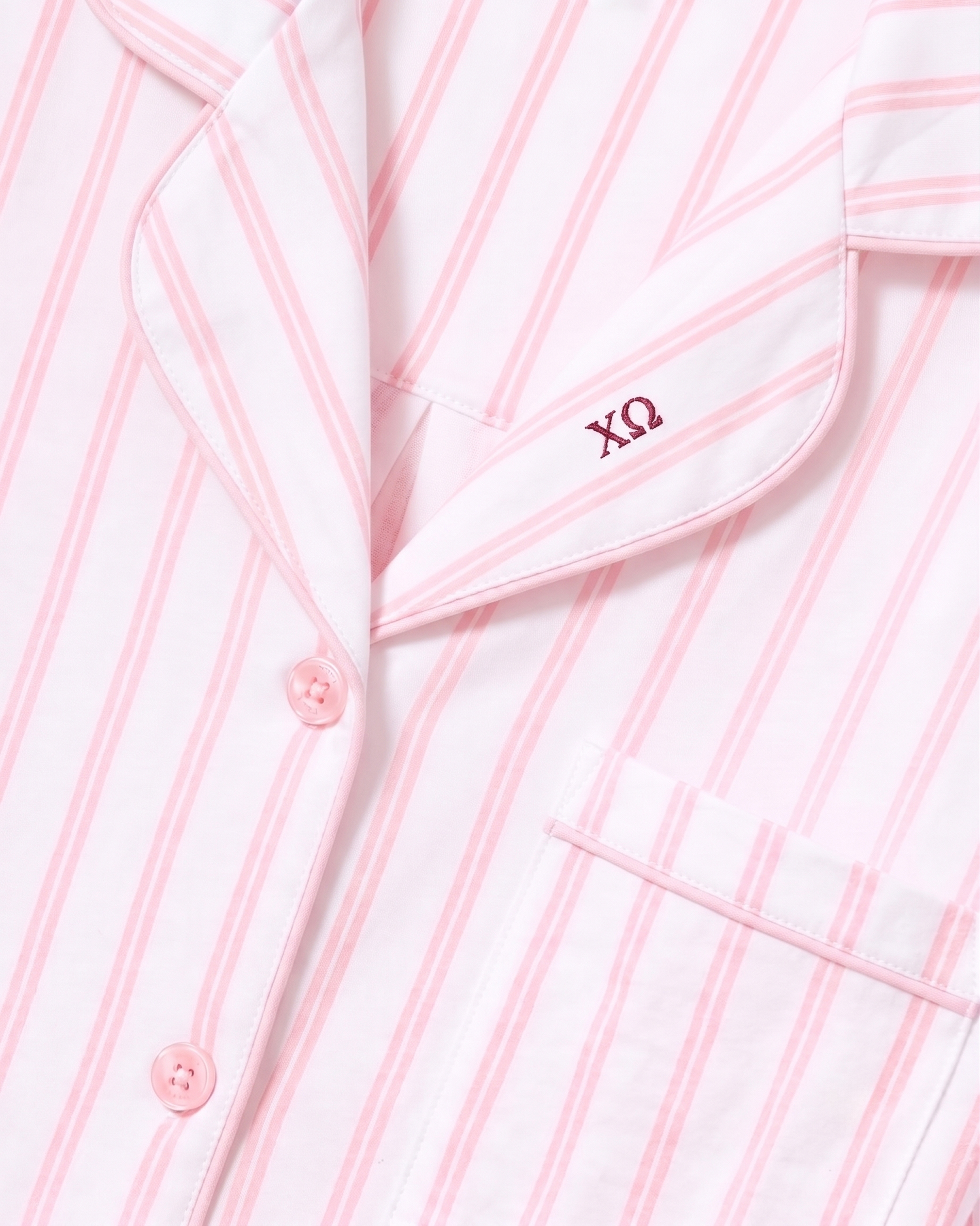Close-up of the Greek Embroidered Women’s Pima Pajama Set in Pink Stripe, featuring pink buttons, a pocket, and embroidery of the Greek letters ΧΩ above the pocket.