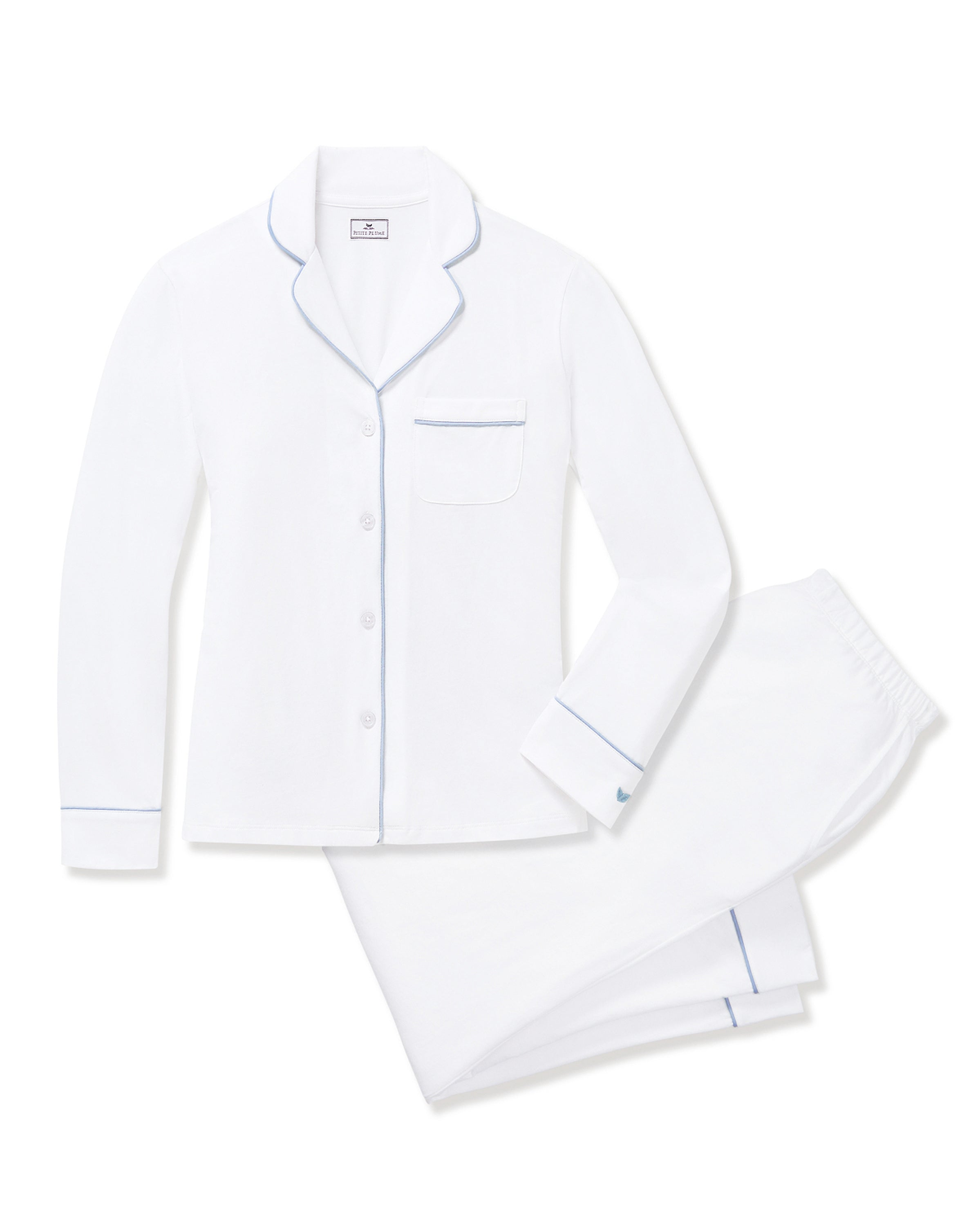 The Women's Pima Pajama Set in White with Periwinkle Piping features a long-sleeve button-up top with a chest pocket and matching pants, both trimmed with periwinkle piping along the collar, cuffs, pocket, and pant hems.