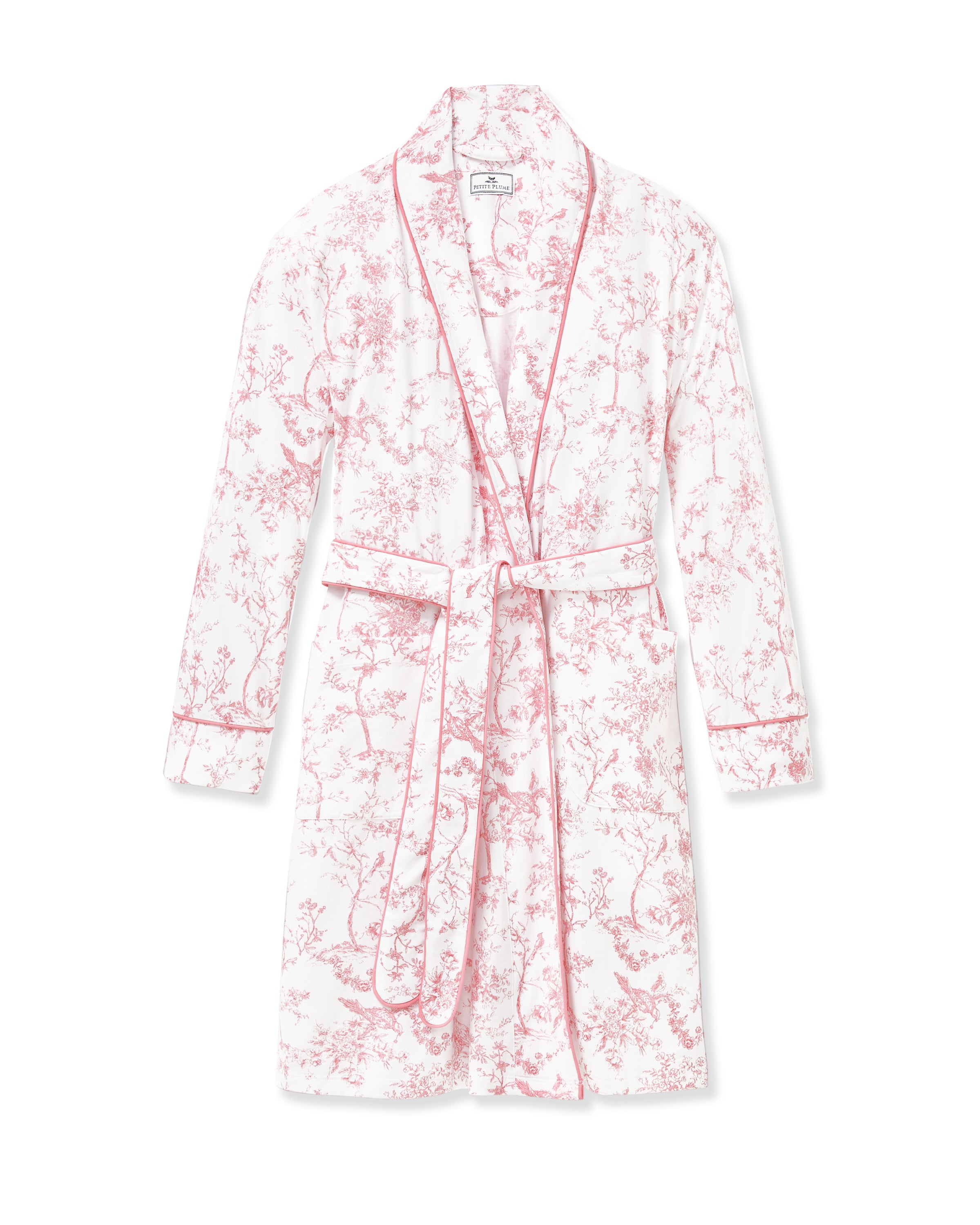 The Women's Pima Robe in Pink Timeless Toile features a white knee-length design with a pink floral toile pattern, long sleeves, a shawl collar, and a matching waist belt.
