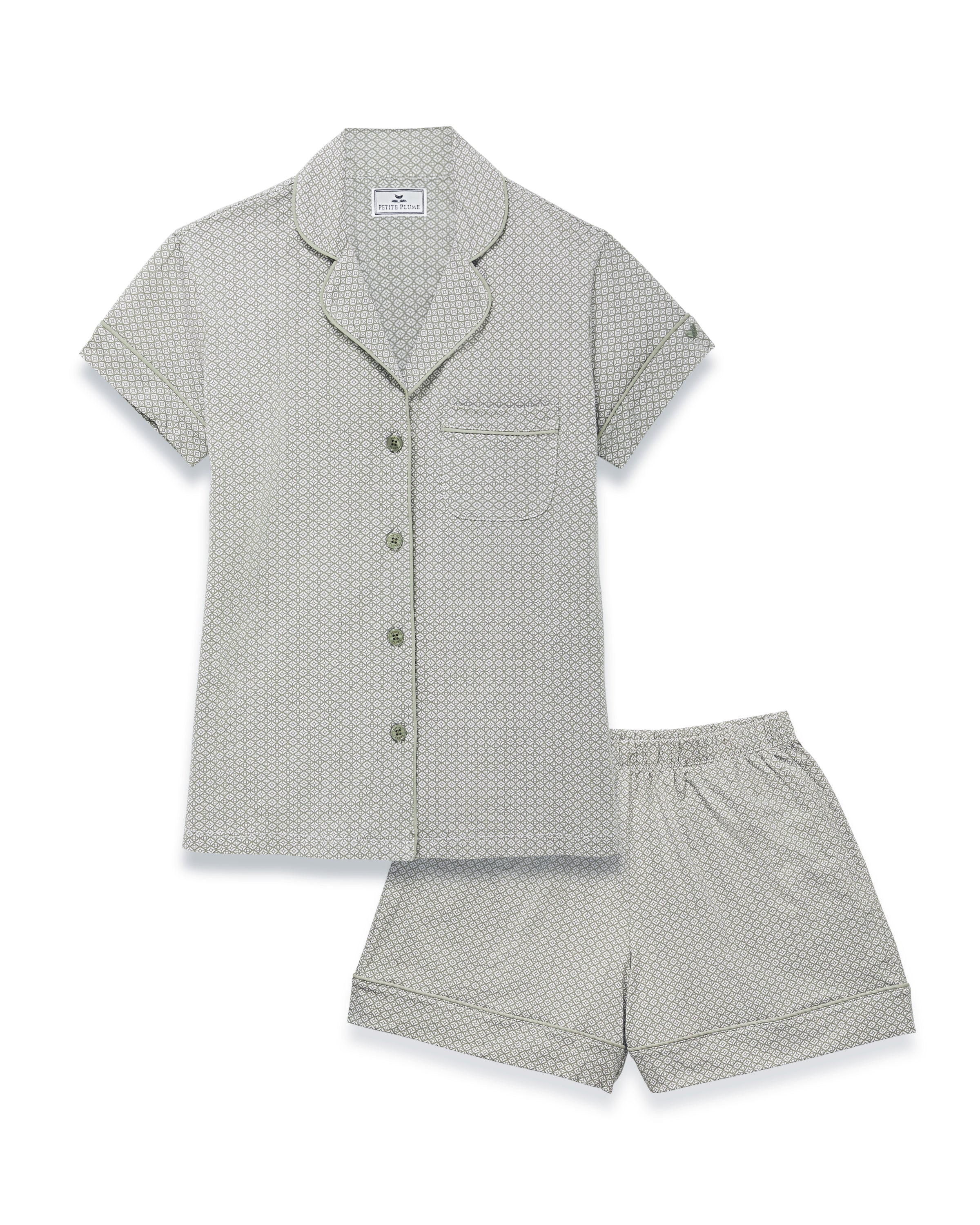 A woman stands barefoot in the Women's Lightweight Pima Short Sleeve Short Set in Sage Geo—featuring a button-up shirt and matching shorts with a small geometric pattern—against a plain light background.