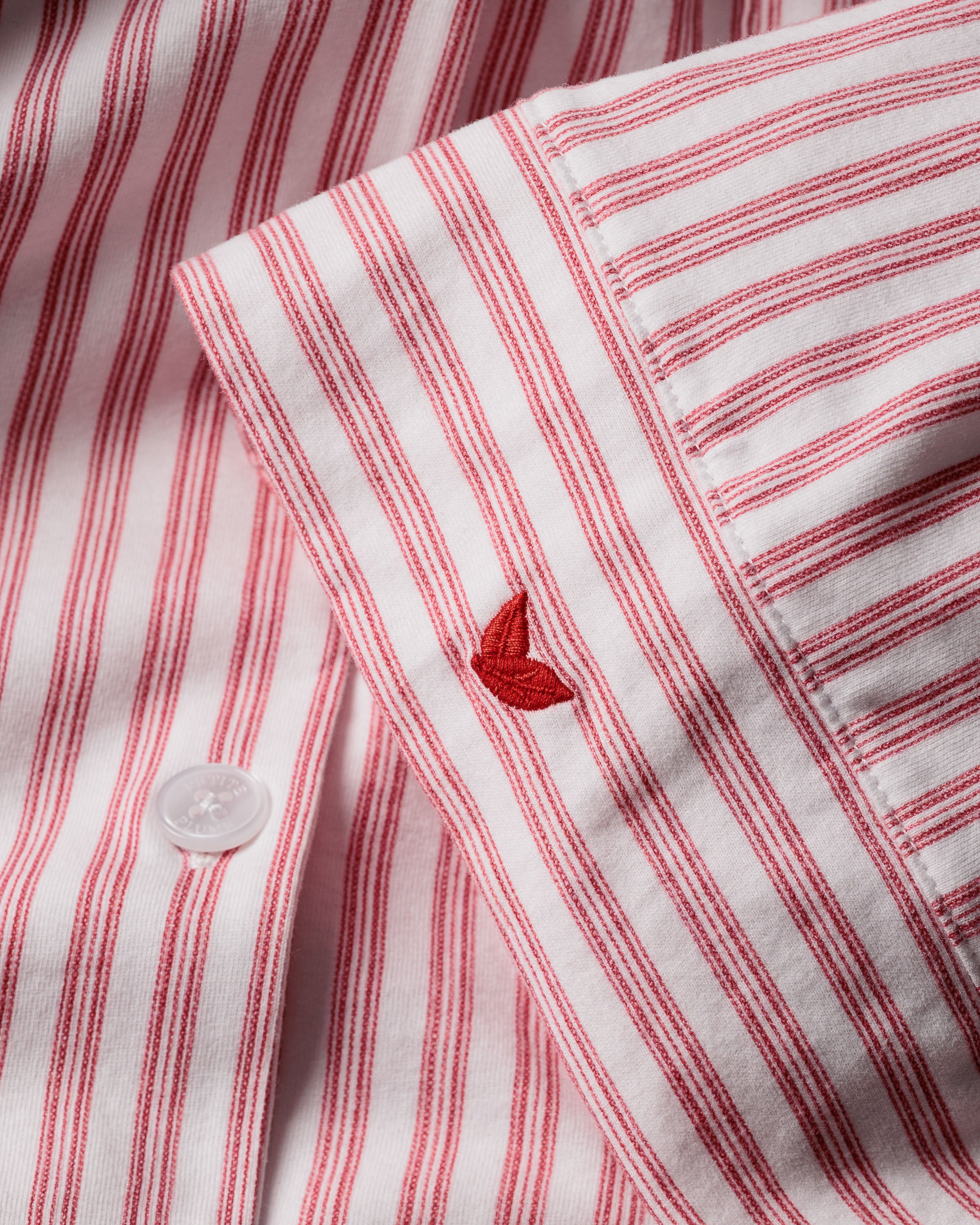 Featuring the Petite Plume Olivia Pajama Set in Antique Red Ticking, this shirt is crafted from luxurious Peruvian Pima cotton with an embroidered logo on its sleeve and a classic white button front design.