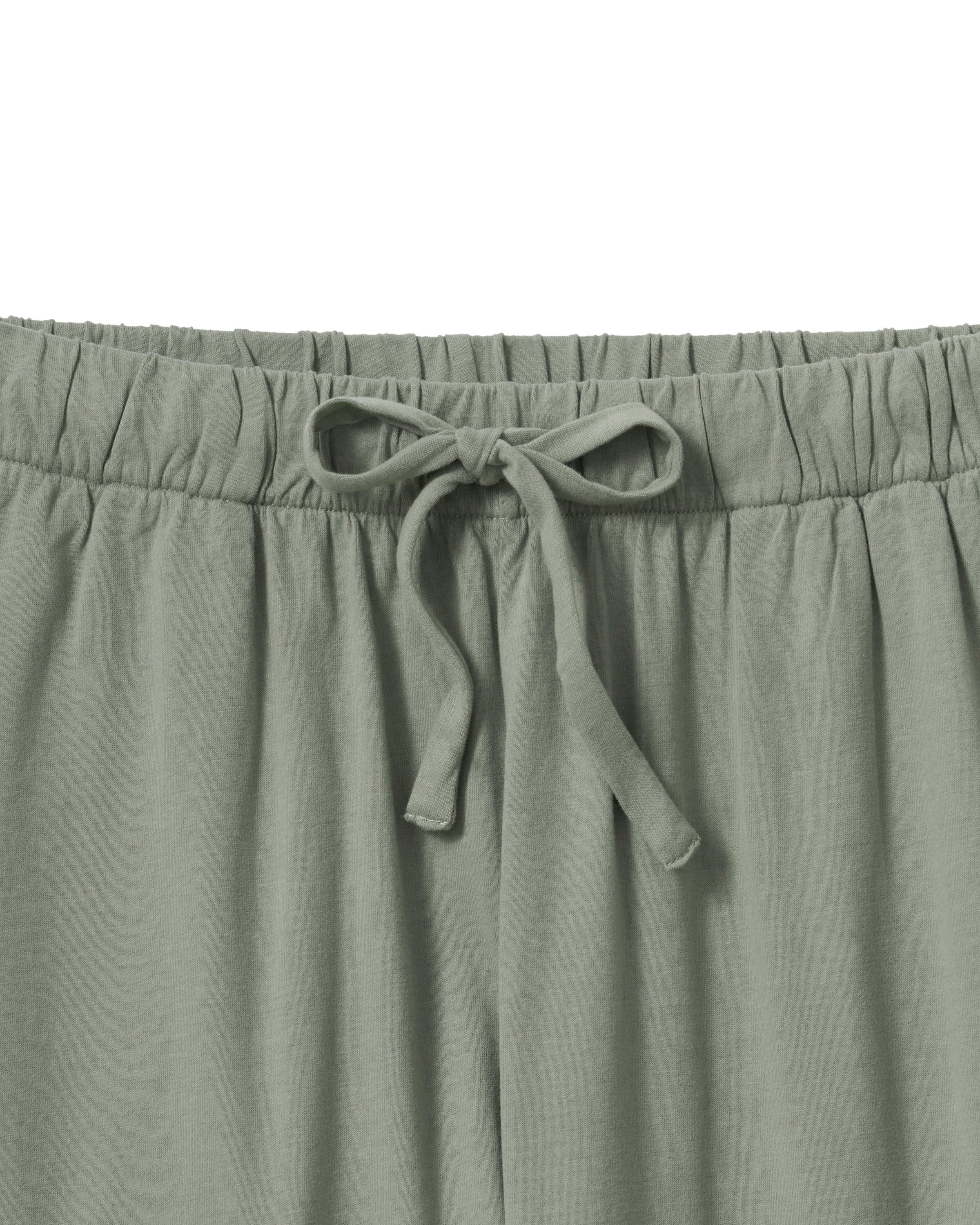 The Olivia Wide Leg Pima Pajama Set in Sage includes a button-up, collared top with a chest pocket and three-quarter sleeves, plus matching elastic waist wide-leg pants. Both pieces are neatly laid flat on a white background.