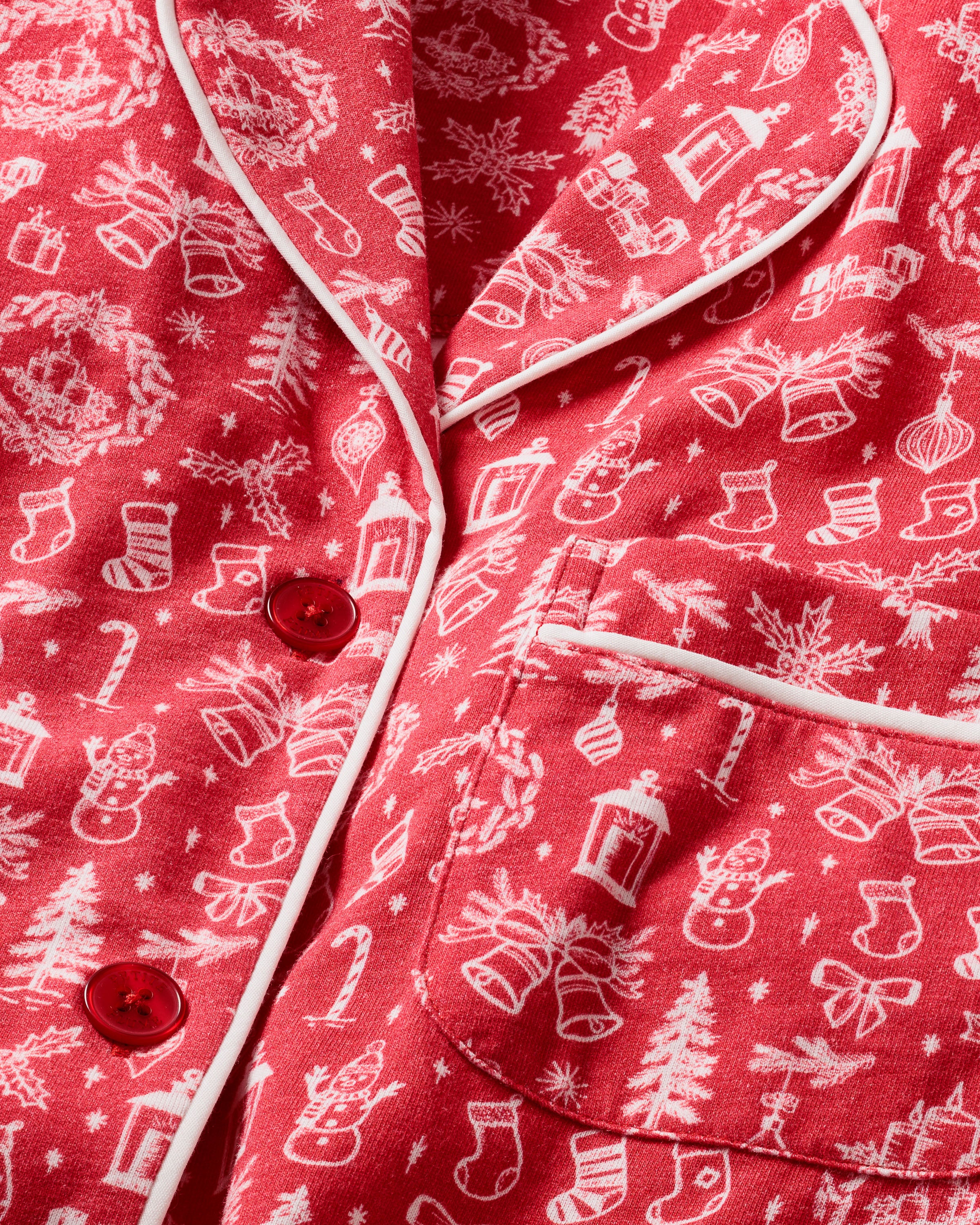 Close-up of the Mens Pima Pajama Set in Whimsical Winter by Petite Plume, crafted from luxurious Peruvian Pima cotton. Adorned with red buttons and white piping, it features festive patterns like snowmen, candy canes, stockings, trees, and wreaths for ultimate luxury sleepwear.