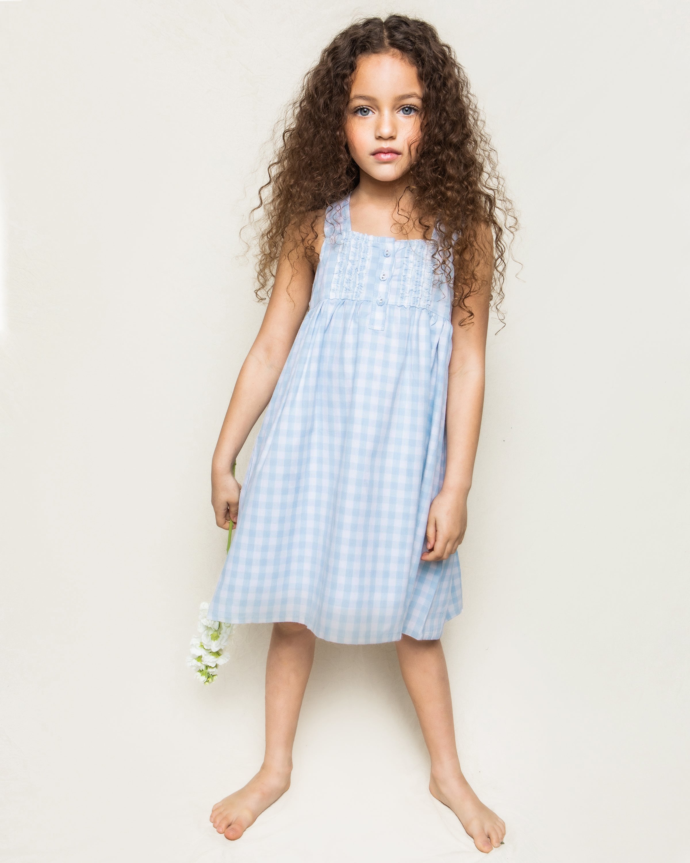 Girl's Twill Charlotte Nightgown in Light Blue Gingham with sleeveless design, ruffle accents, chest buttons, gathered waist, and a loose, flowy skirt.