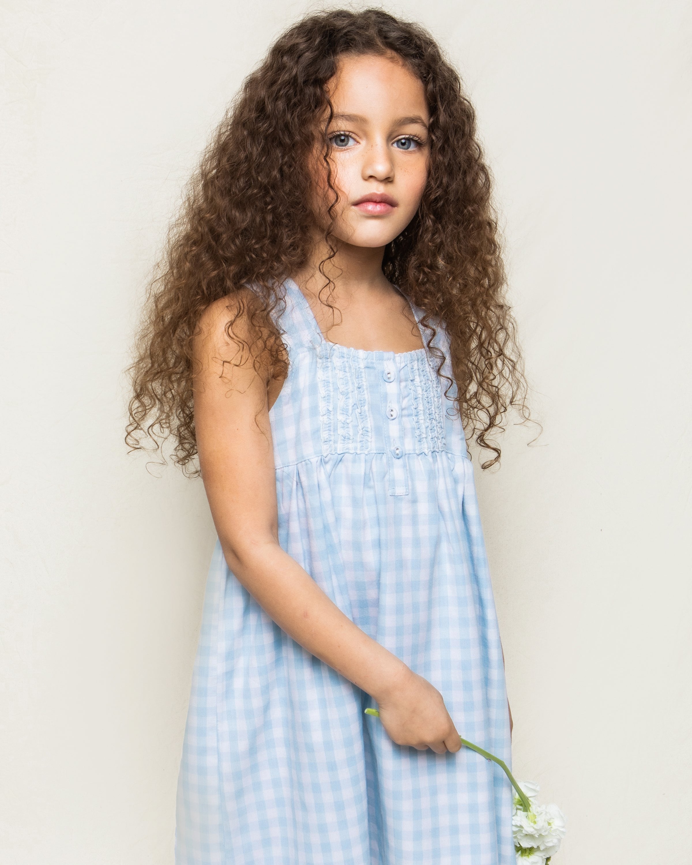 Girl's Twill Charlotte Nightgown in Light Blue Gingham with sleeveless design, ruffle accents, chest buttons, gathered waist, and a loose, flowy skirt.
