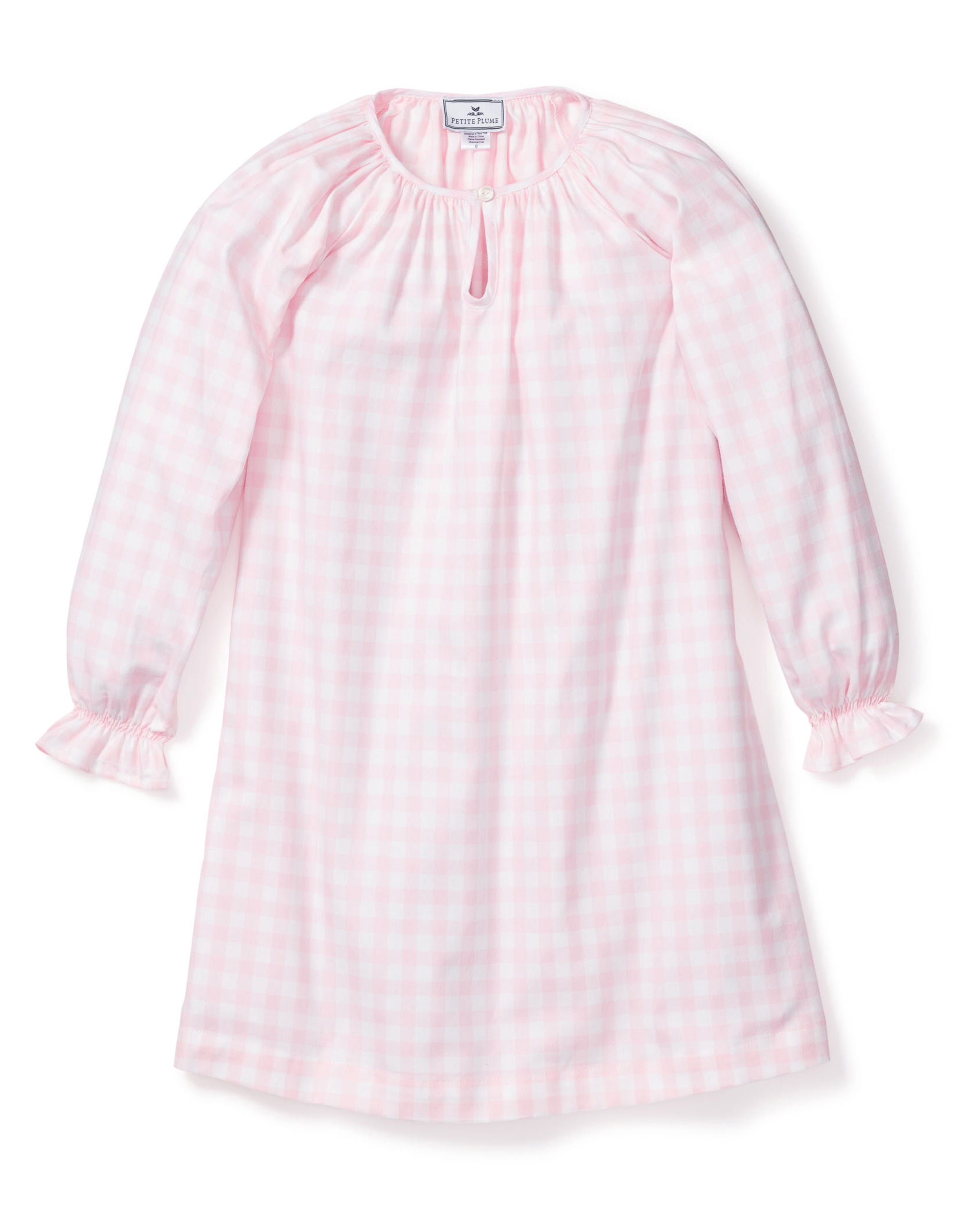 The Petite Plume Girls Twill Delphine Nightgown in Pink Gingham features long sleeves, a rounded neckline with a small keyhole opening, and ruffled cuffs, made from flame-retardant fabric.