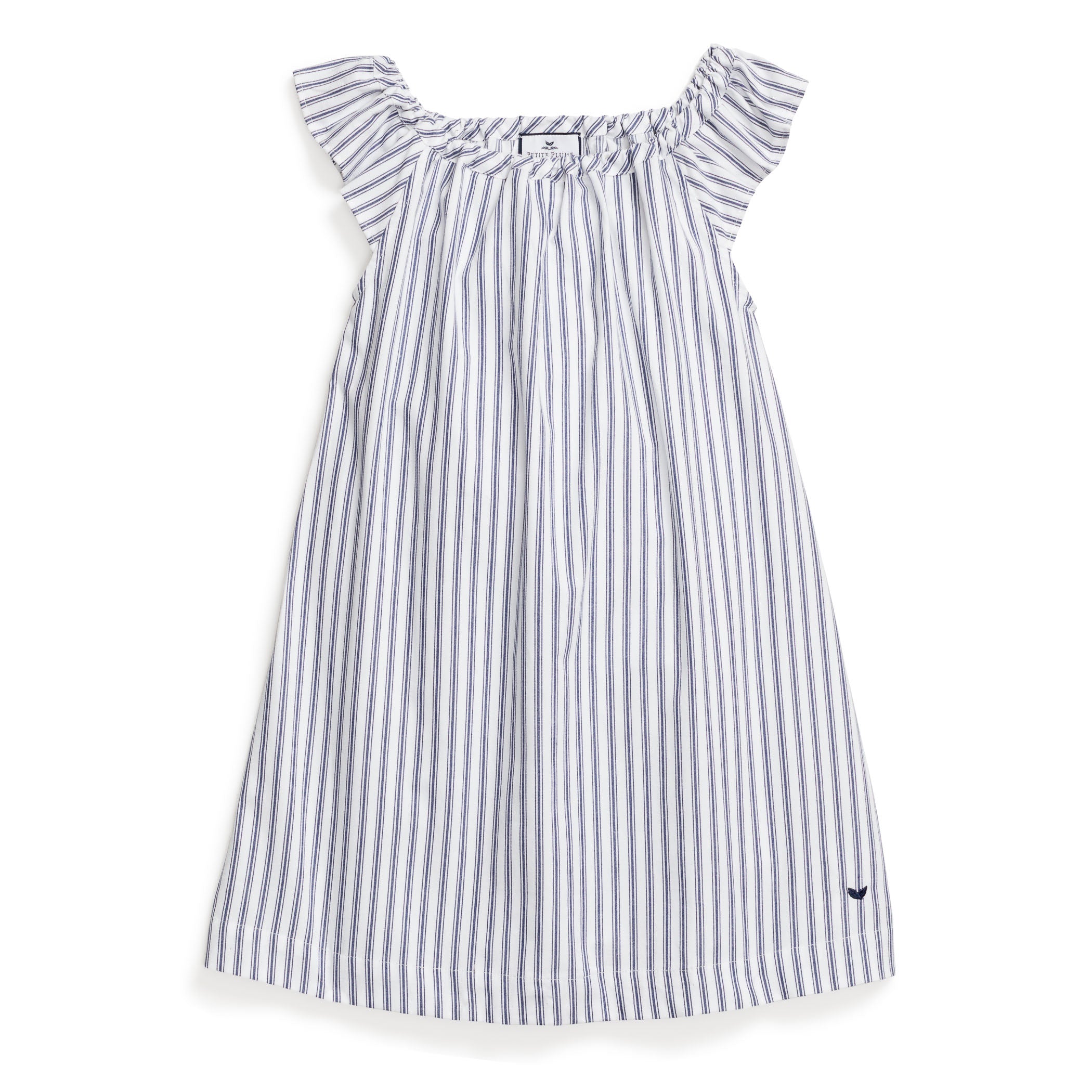 The Girls Twill Isabelle Nightgown by Petite Plume in Navy French Ticking is made of yarn-dyed cotton with light gray and white stripes, featuring ruffled shoulders and a small dark blue embroidered logo near the hem for a loose, flowing fit.
