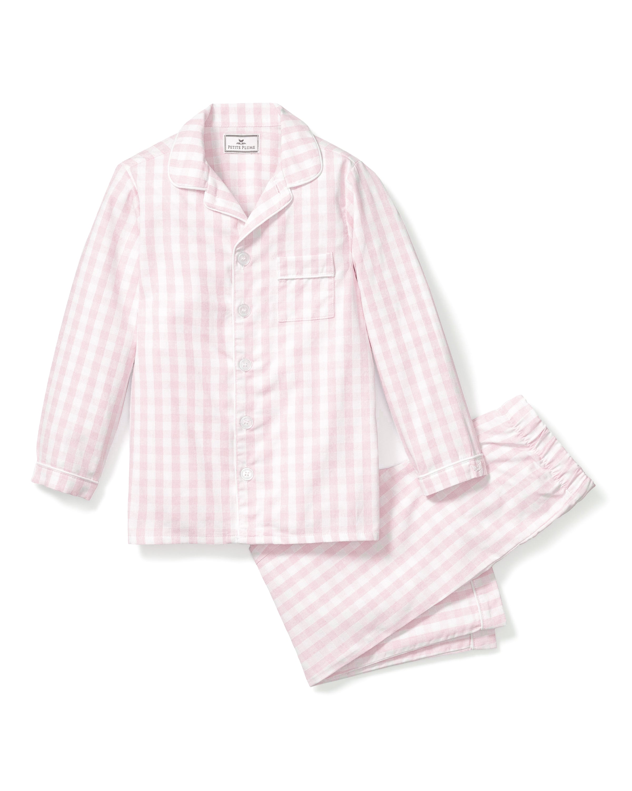 The Kids Twill Pajama Set in Pink Gingham by Petite Plume is crafted from yarn-dyed cotton and features a pastel pink and white gingham print. The long-sleeve button-up top includes a chest pocket, while the matching pants have an elastic waistband for comfort.