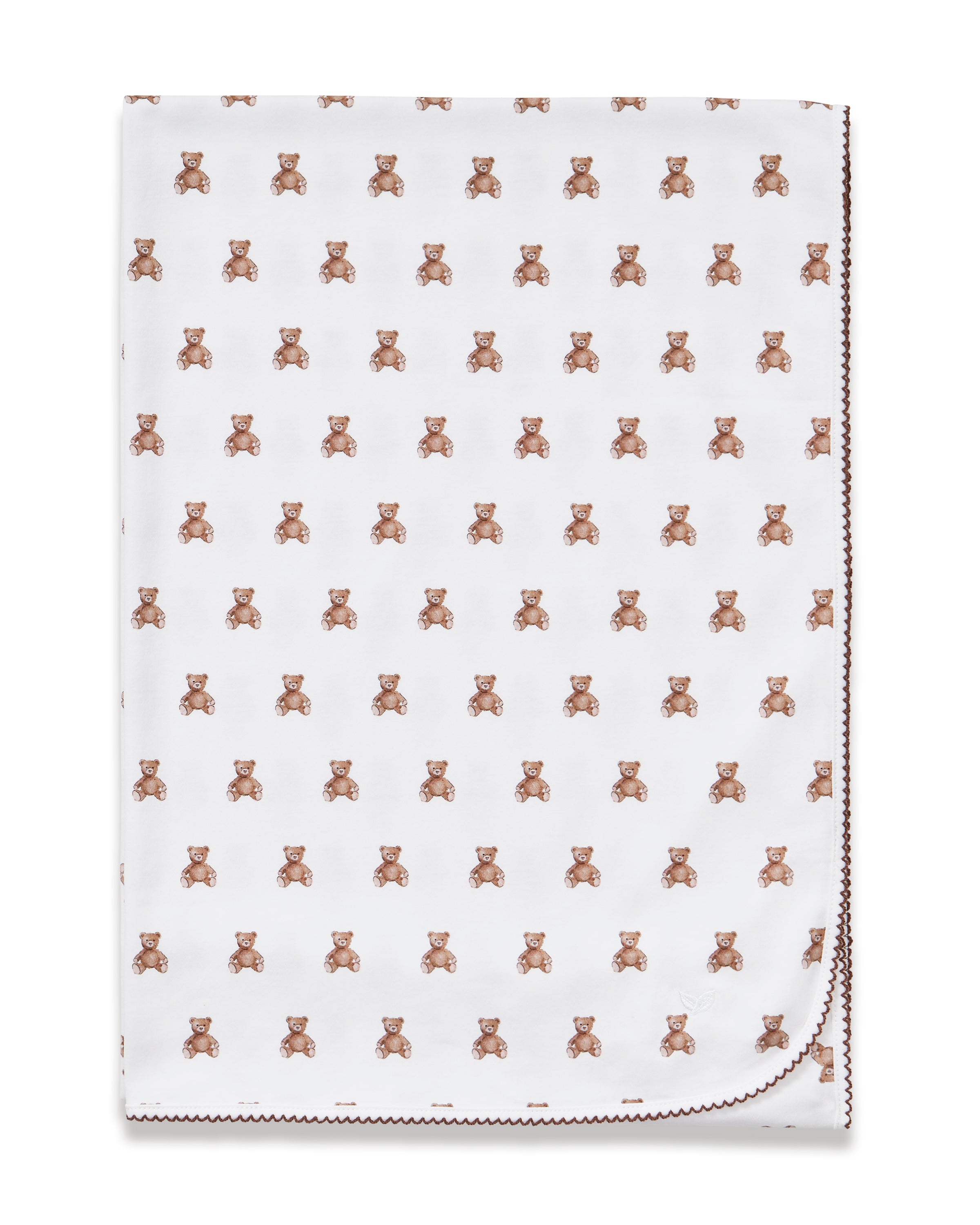 The Pima Baby Blanket in Teddy Tales features a soft white fabric with a repeating pattern of small brown teddy bears and a red-stitched border.