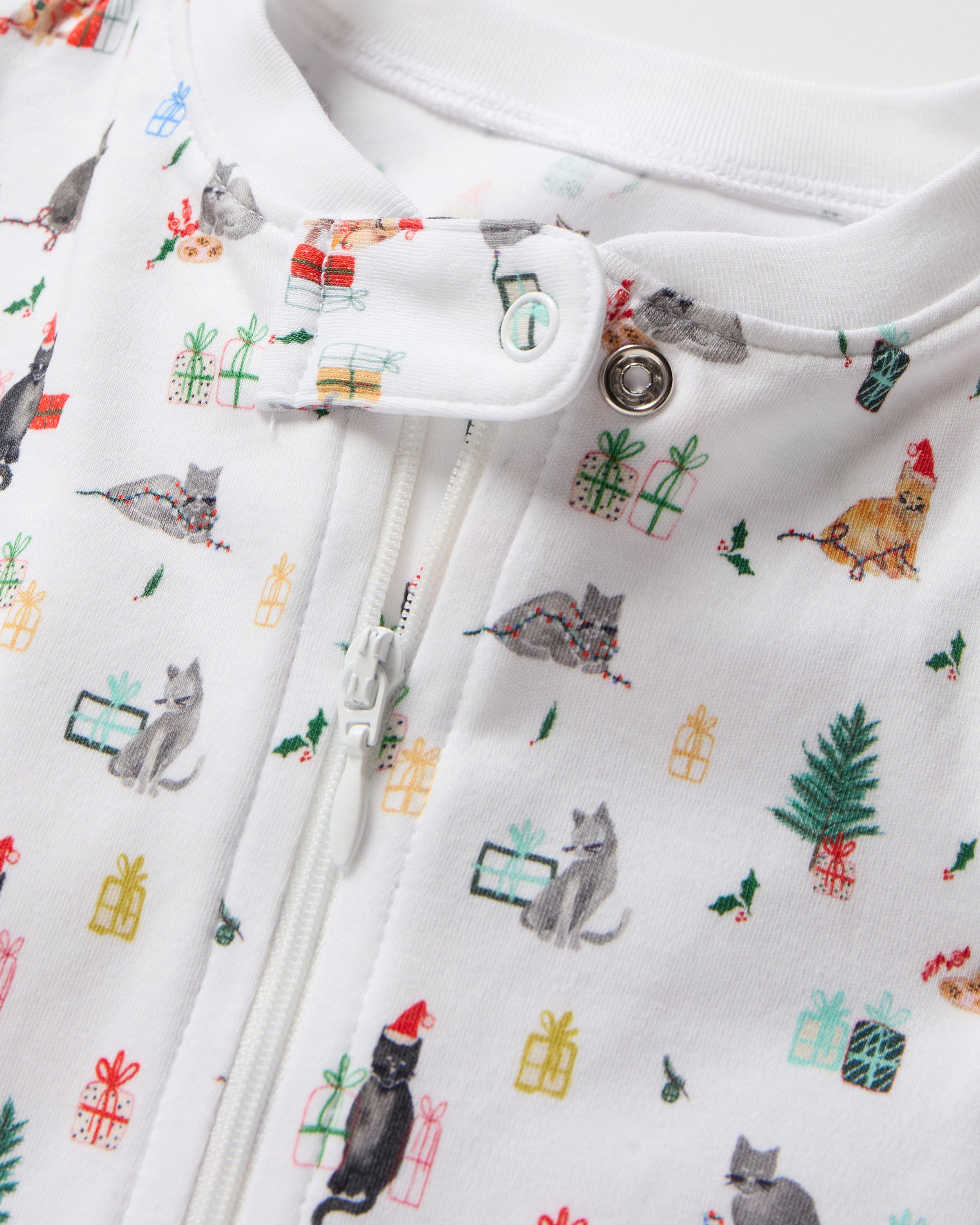 The Baby's Pima Romper in Merry Meow is a white onesie with a front zipper, covered feet, long sleeves, and playful prints of animals, trees, and people enjoying outdoor adventures like camping and fishing.