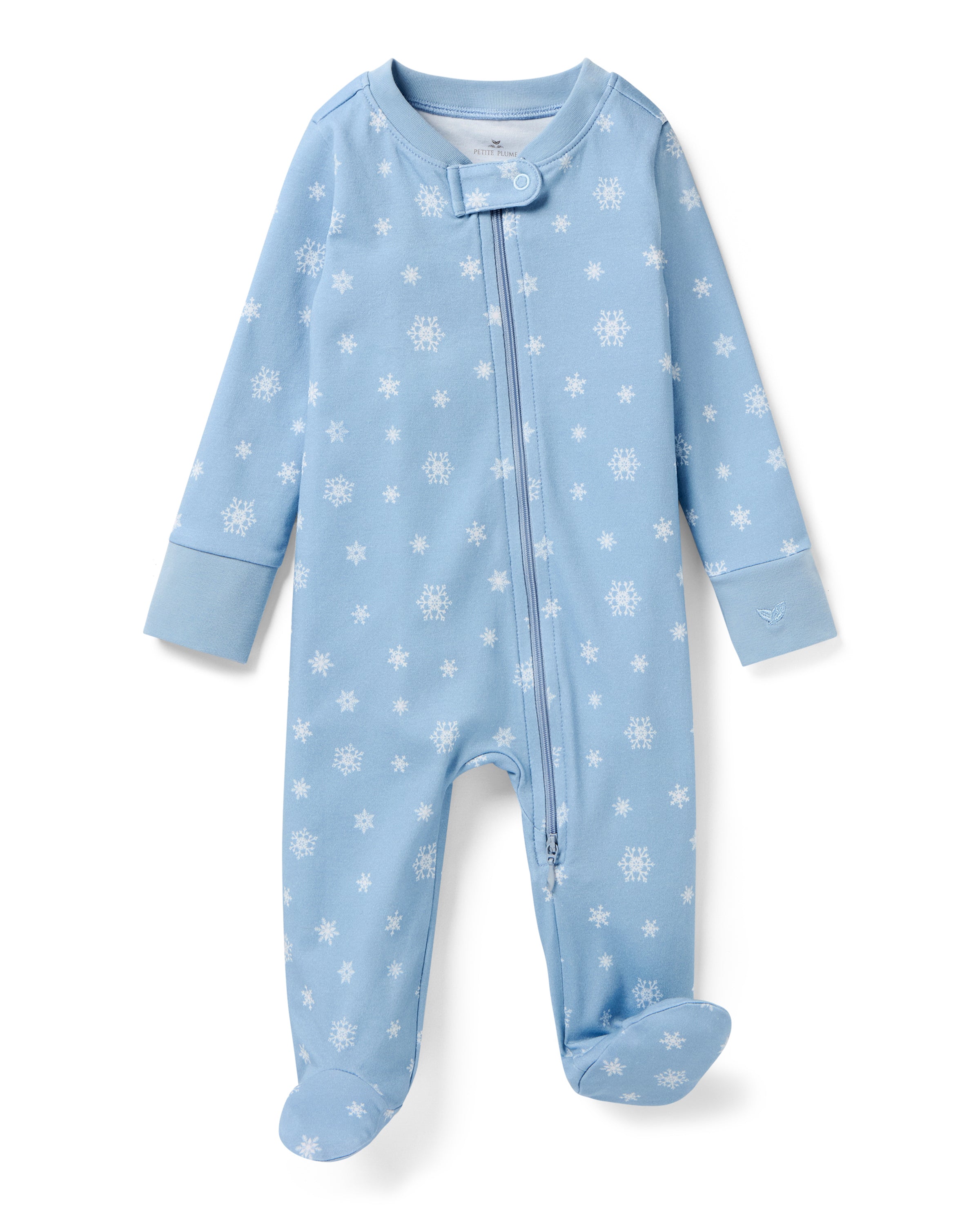The Baby's Pima Romper in Periwinkle Wonderland is a light blue onesie with long sleeves, covered feet, white snowflake pattern, diagonal zipper from neckline to left ankle, and a small fabric snap at the neck.