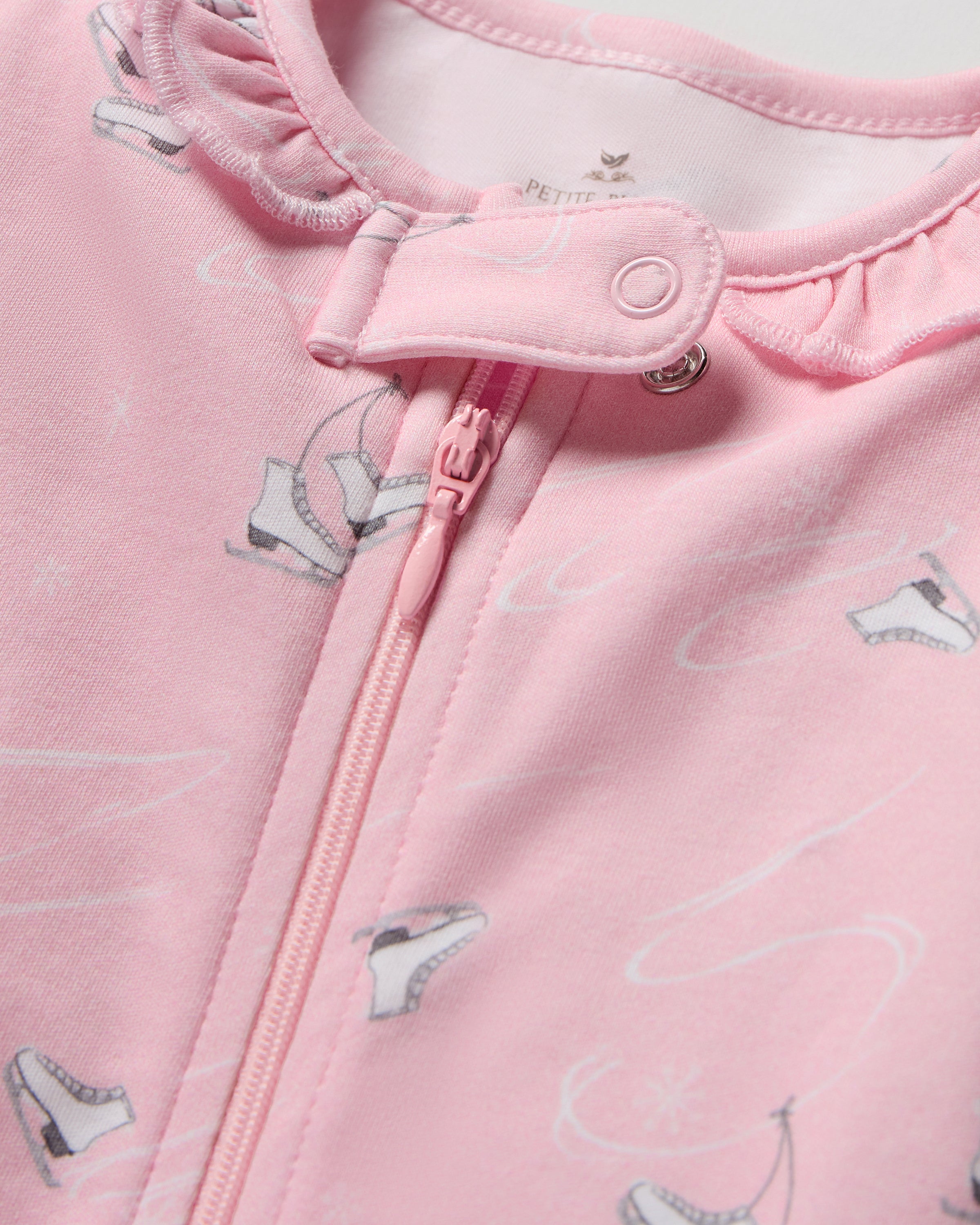 A pink, long-sleeved Baby's Pima Romper in Winter Skates, featuring a front zipper, white and gray skating print, and delicate ruffles around the collar.