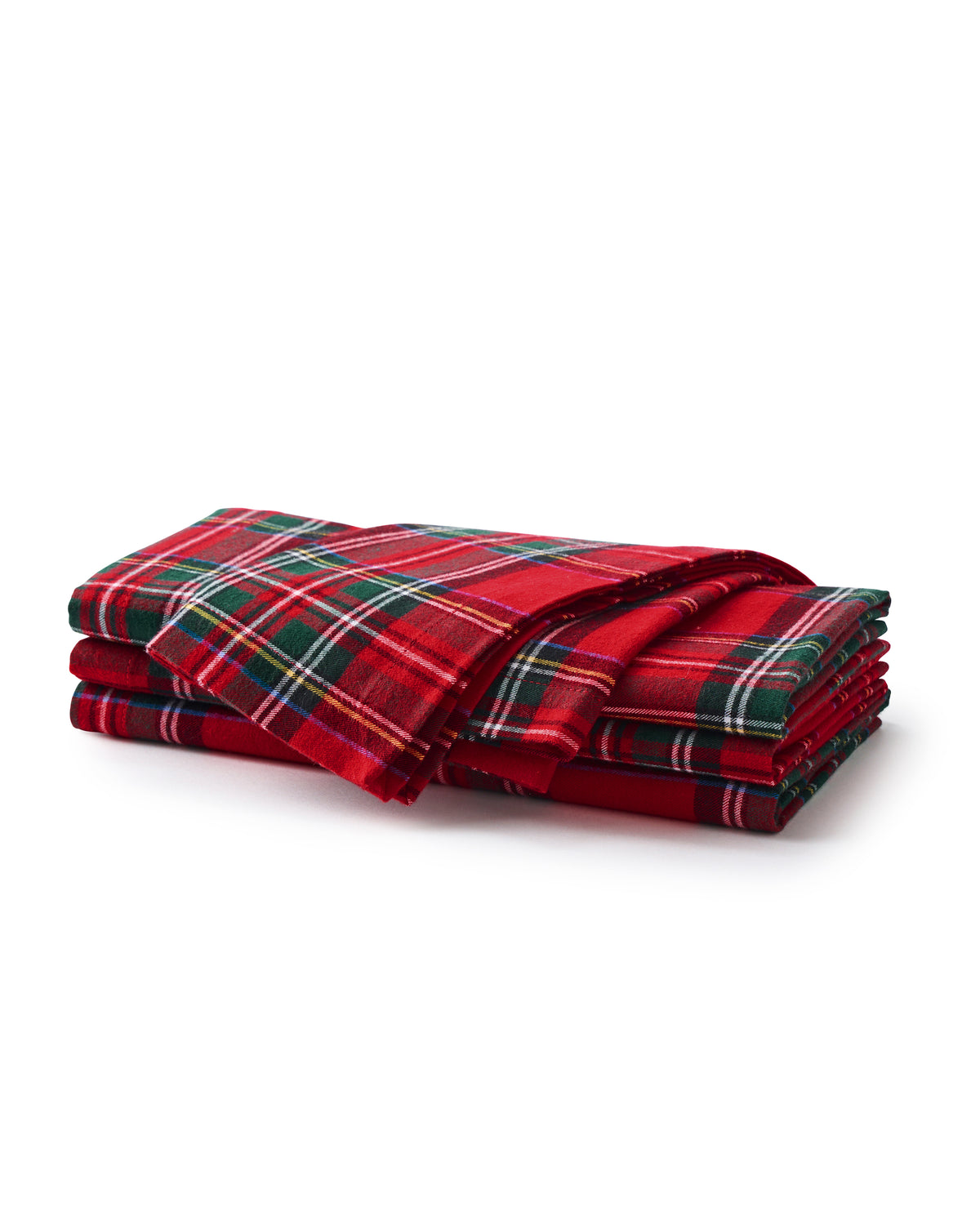 A dining table set featuring Signature Twill Napkins in Imperial Tartan by Petite Plume crafted from cotton textiles. Silver cutlery accompanies white plates, while crystal glassware and a small candle holder enhance the festive tablescape, creating an elegant setting.