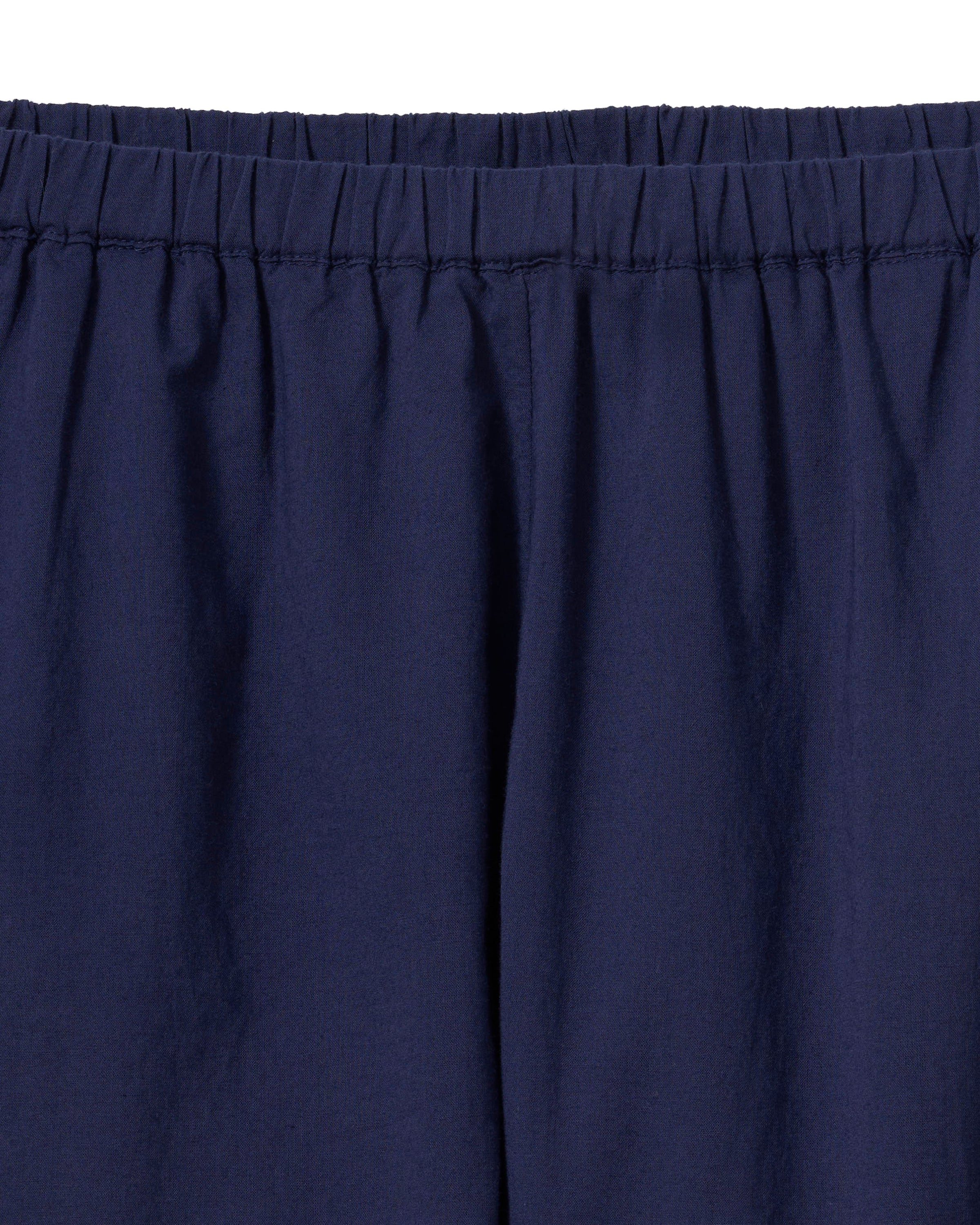 A woman stands barefoot against a plain light background, wearing the Women's Voile Fleur Cami Pant Set in Navy.