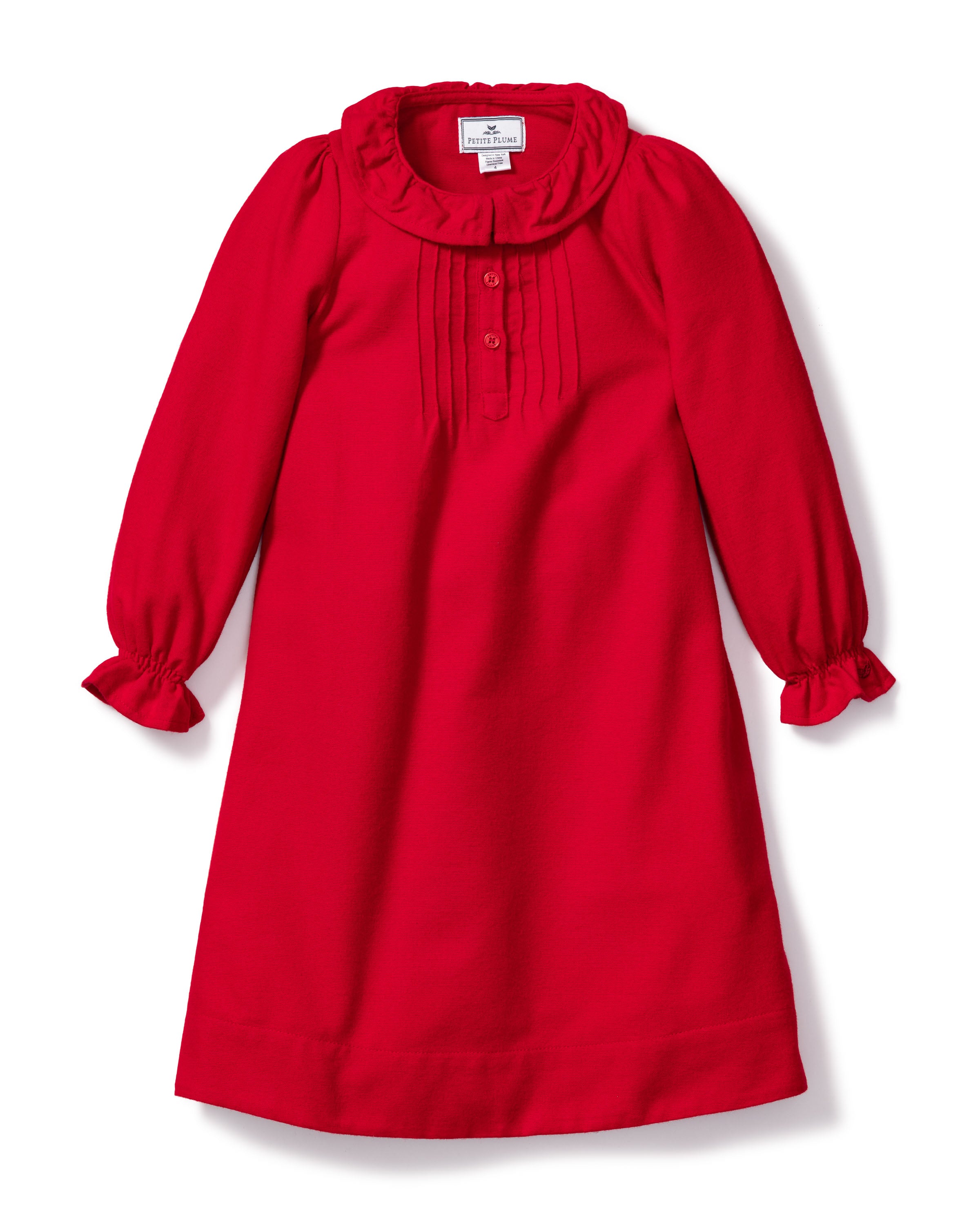 The Girls Flannel Victoria Nightgown in Red by Petite Plume features a ruffled collar and cuffs. Made from flame-retardant fabric with vertical pleats on the bodice, this soft, elegant piece combines safety and style for various occasions.