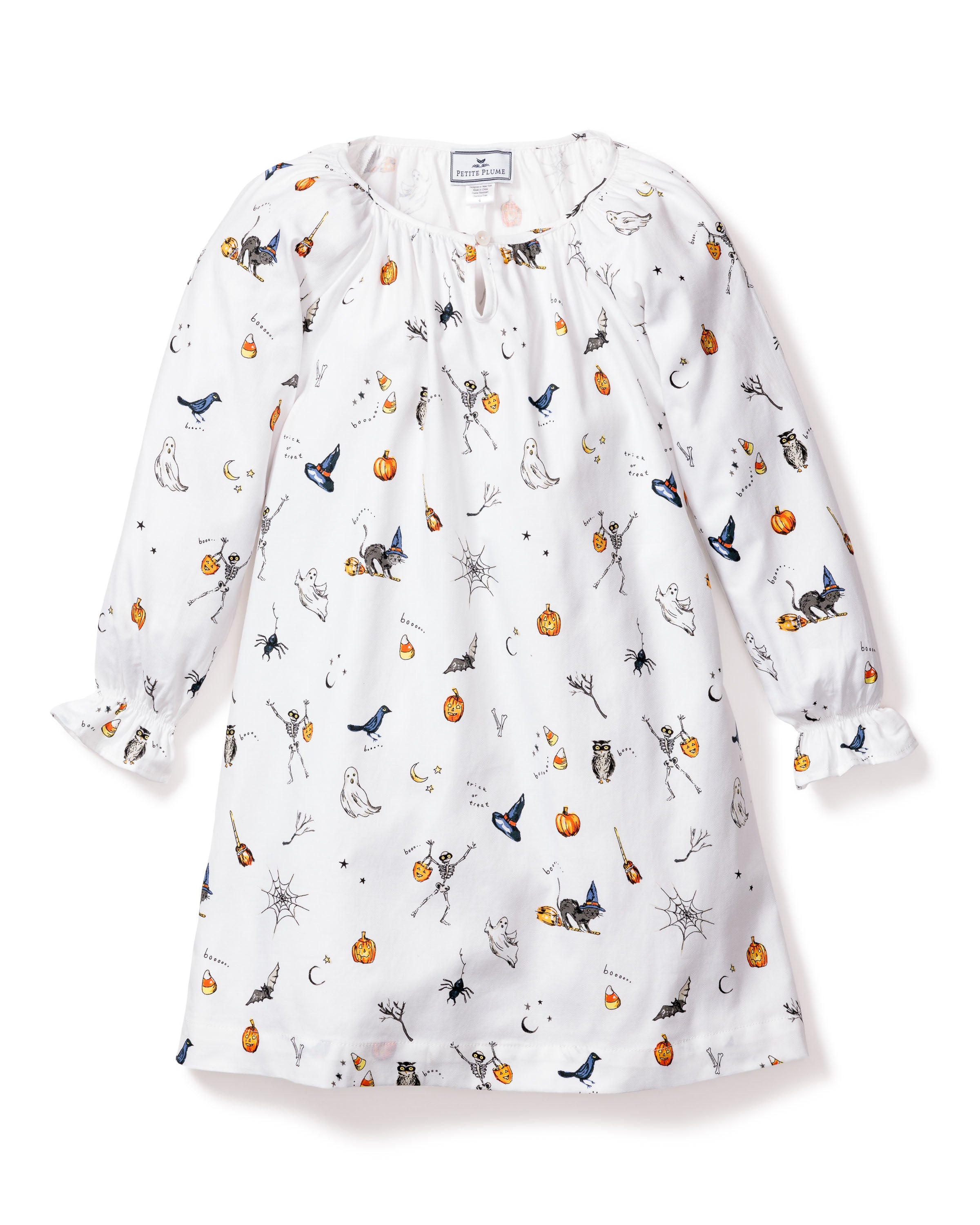The Petite Plume Girls Twill Delphine Nightgown in Trick or Treat showcases Halloween-themed prints like pumpkins, ghosts, and bats. This white long-sleeve gown features gathered sleeves and a button-fastened neckline, ideal for the festive season.