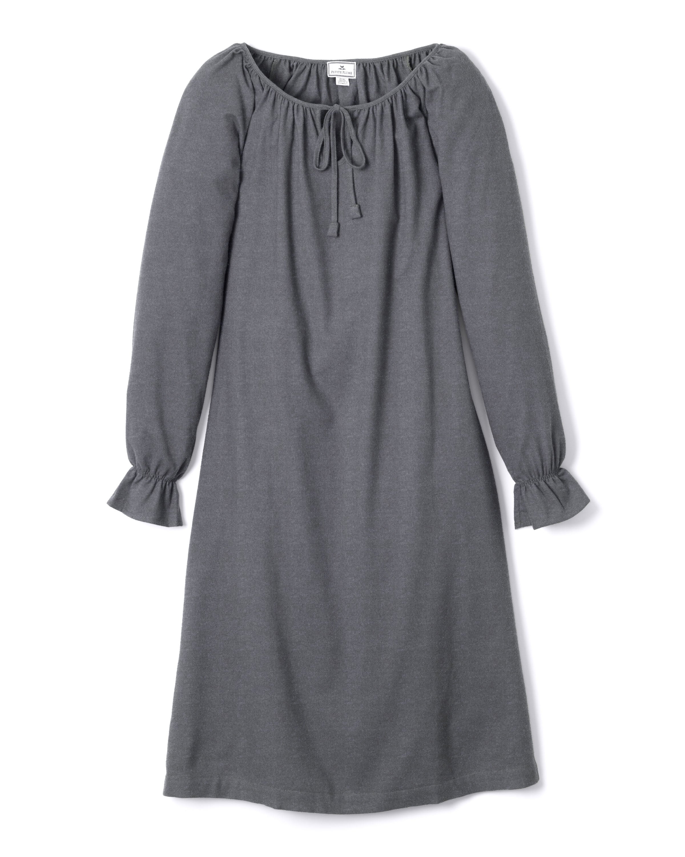 The Womens Flannel Delphine Nightgown in Grey by Petite Plume showcases a long-sleeve, off-shoulder design with a drawstring neckline. Made of soft flannel, its sleeves feature gathered ruffle cuffs for a loose, comfortable fit.