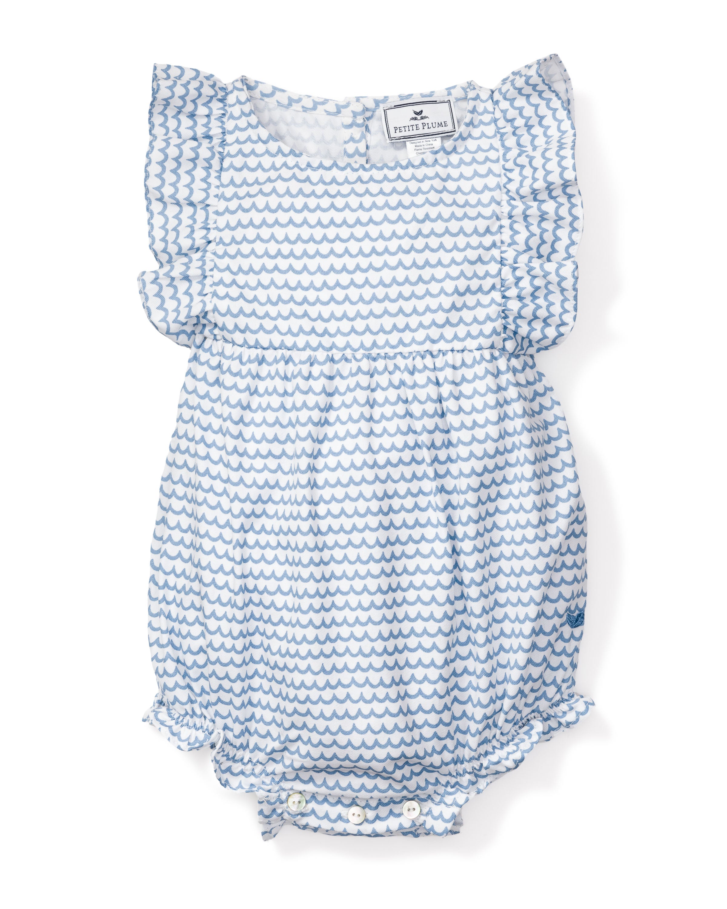 The Babys Twill Ruffled Romper in La Mer by Petite Plume features a blue and white pattern with ruffled sleeves and legs, crafted from yarn-dyed cotton. Its design mimics Victorian sleepwear, with a wavy motif and convenient bottom buttons for easy fastening.