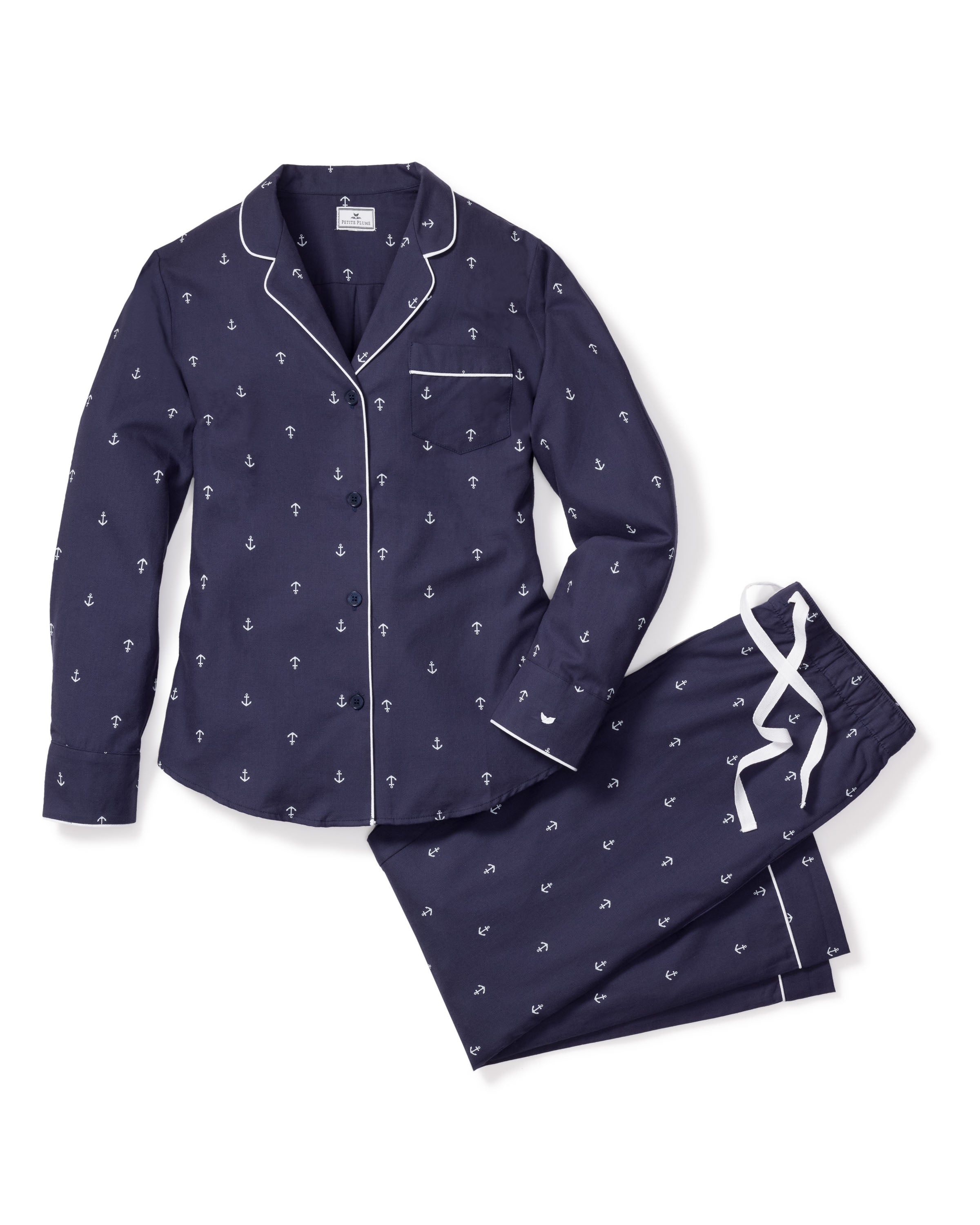 The Womens Twill Pajama Set in Portsmouth Anchors by Petite Plume has a classic navy blue long-sleeved top with white piping and navy anchors, paired with matching pants featuring a white drawstring, made from high-quality cotton.