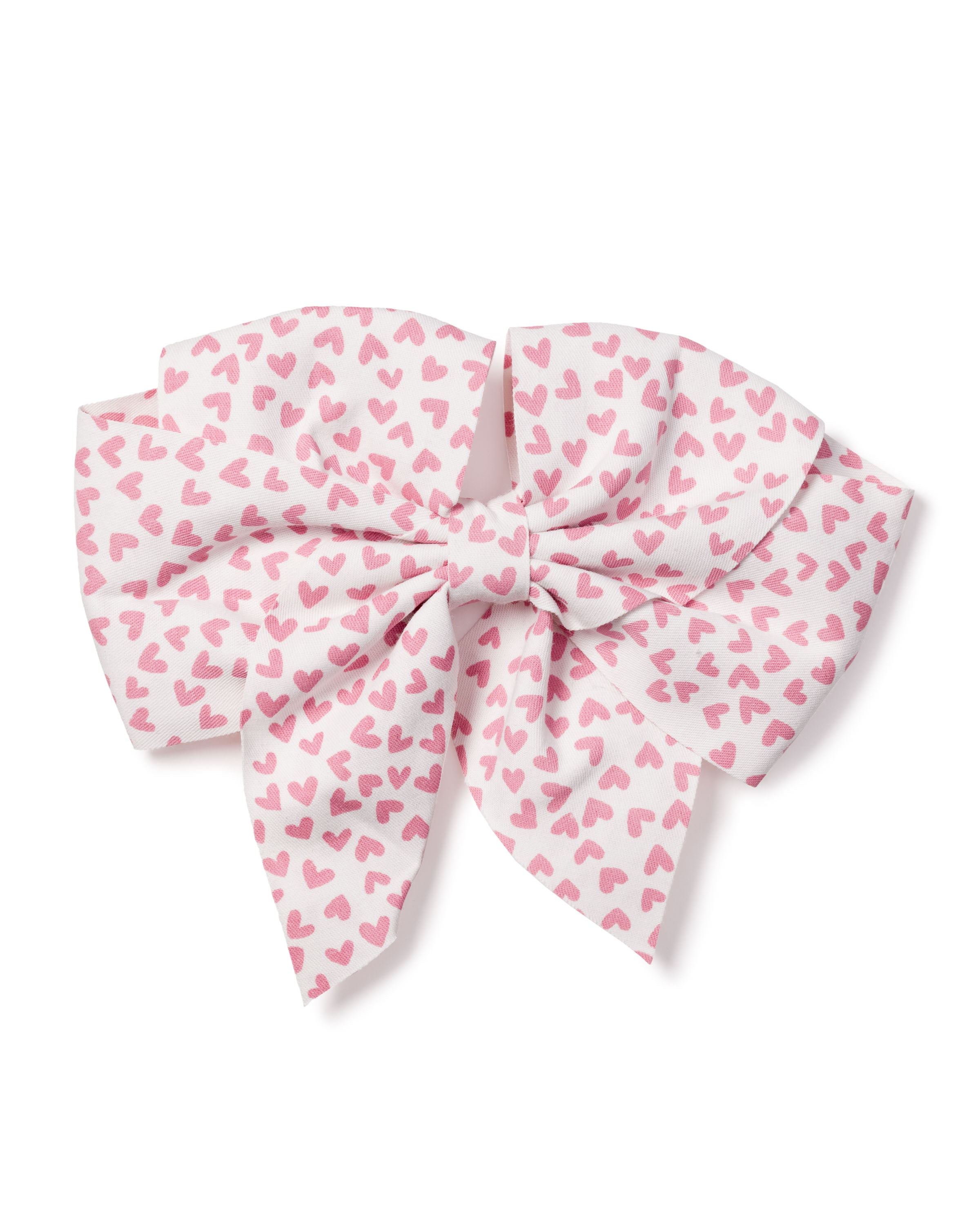 The Petite Plume Girls Hair Bow in Sweethearts is a large fabric bow adorned with a pattern of small pink hearts on white. Neatly tied with layered loops and tails, it offers a fluffy look, making it an ideal festive accessory or charming holiday gift for girls.