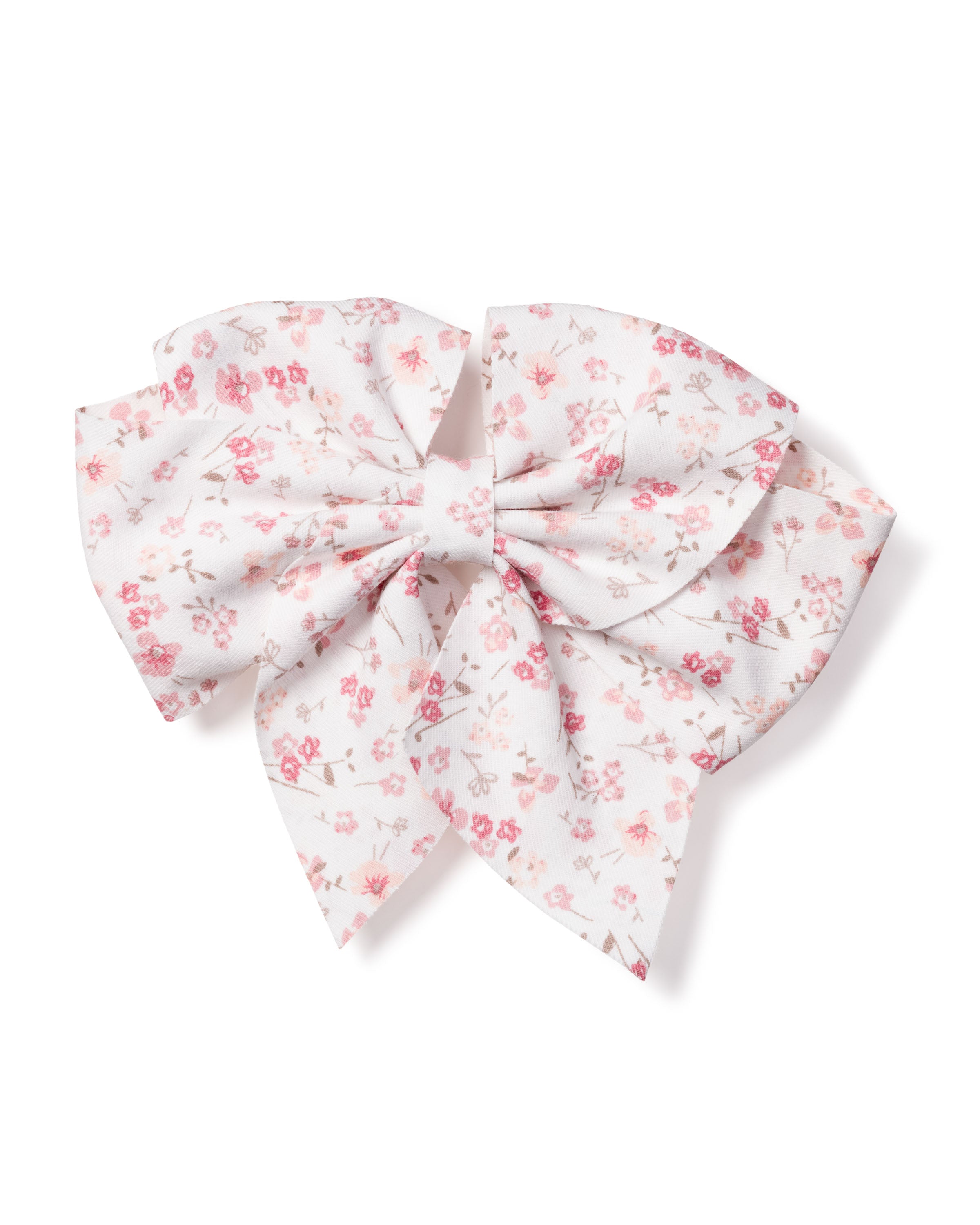The Petite Plume Girls Dorset Floral Hair Bow features a white fabric with small pink flowers and delicate gray leaves, tied in symmetrical loops and tails. Ideal as a holiday gift or charming stocking stuffer.