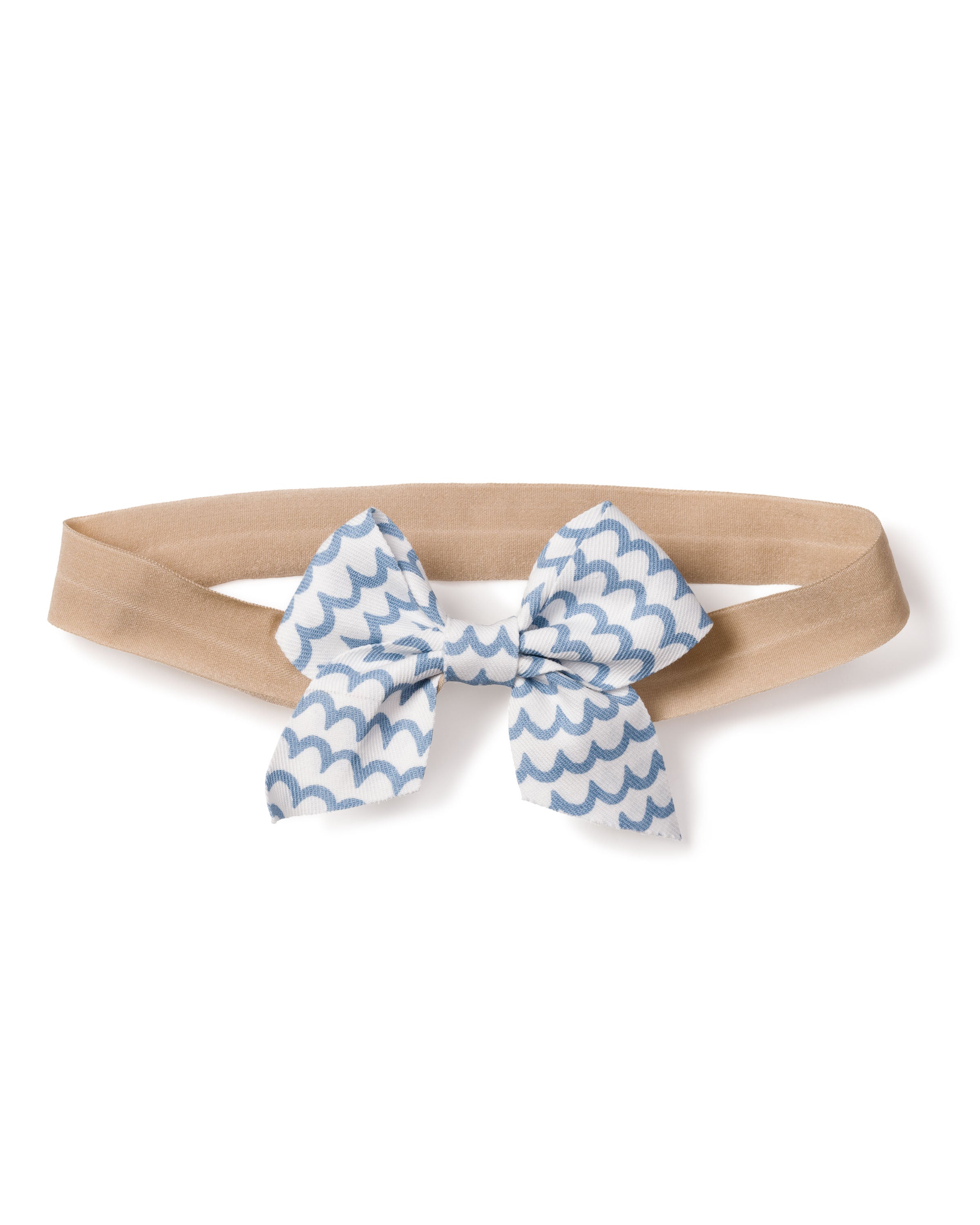 A charming beige elastic headband, adorned with Petite Plumes Girls Hair Bows in La Mer, features a white and blue scalloped wave pattern bow, making it an ideal stylish accessory for girls.