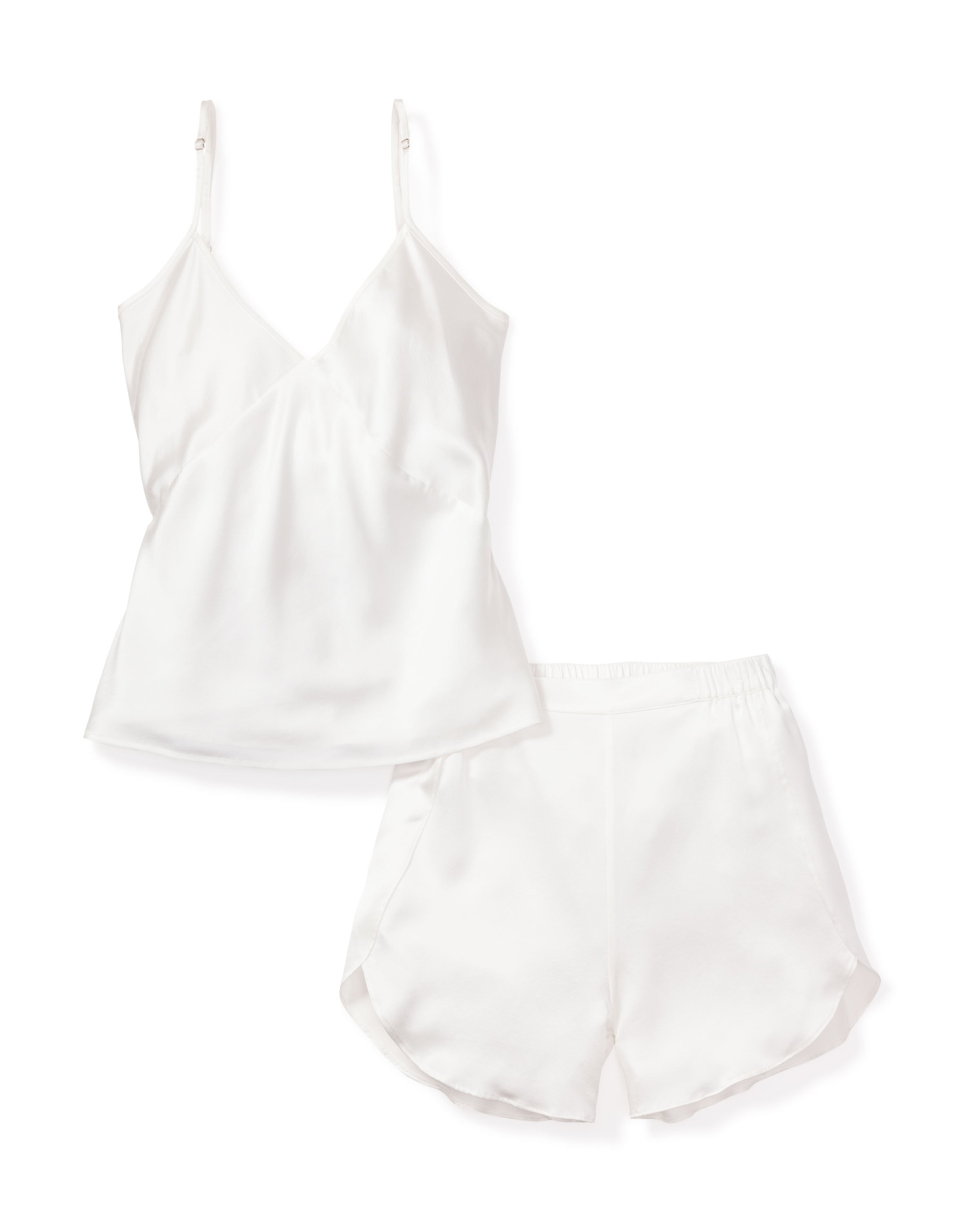 The Womens Silk Cami Short Set in White by Petite Plume features a V-neck satin camisole with thin straps and matching elegant shorts with an elastic waistband and side slits. Both luxury sleepwear items are elegantly displayed flat against a white background, showcasing the essence of silk sleepwear.